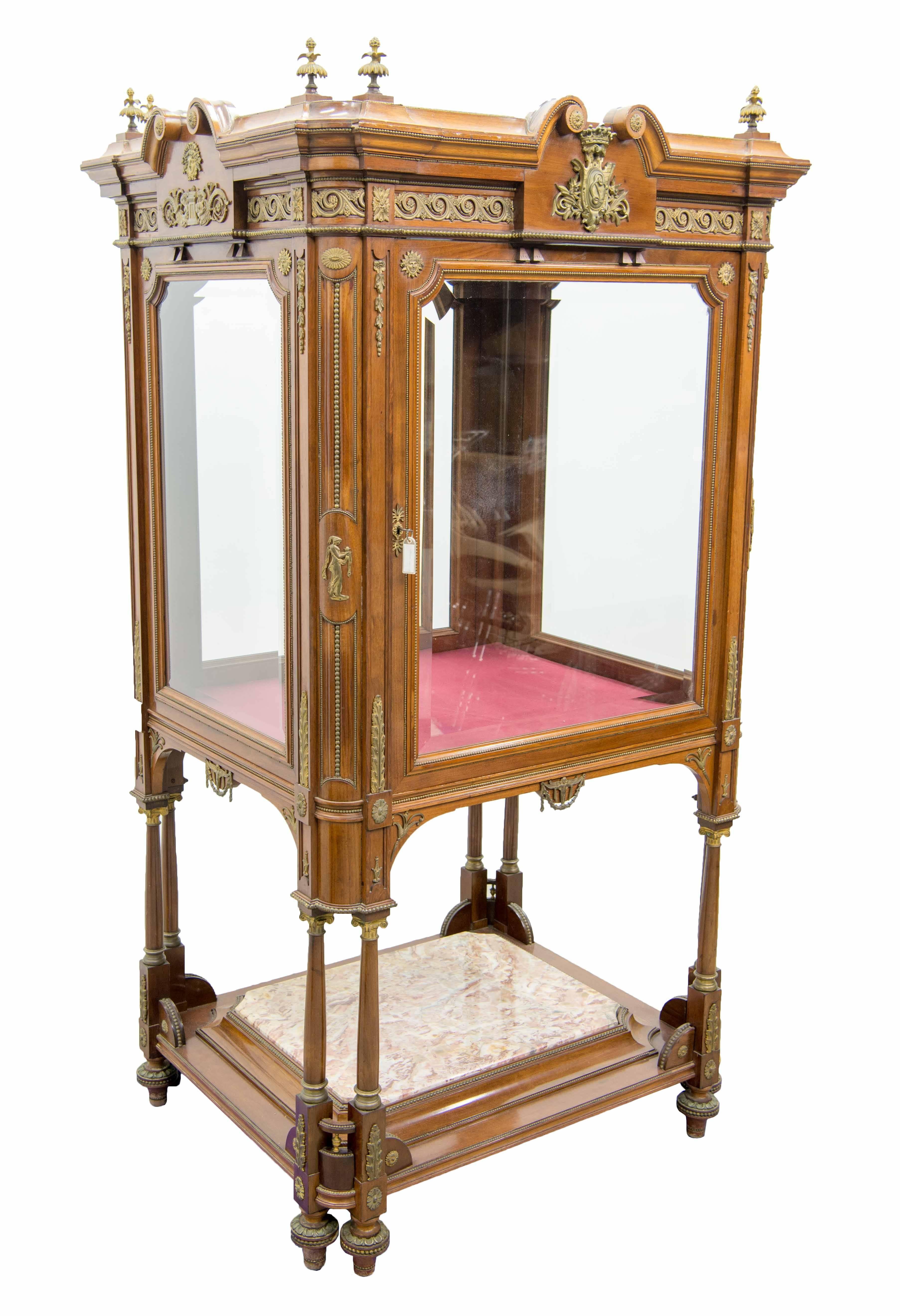 We have this spectacular display cabinet or showcase with glass on all sides for displaying special items. The cabinet is entirely made of walnut with bronze-mounted elements. It is made in Empire style and dating to circa 1850, just after the