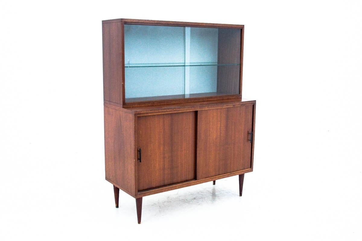 La vitrina se fabricó en la Fábrica de Muebles Wyszkowska en 1968, en Polonia. 

El mueble tiene una pegatina original del fabricante con la fecha exacta de fabricación. La parte superior del mueble es acristalada, tiene puertas correderas de