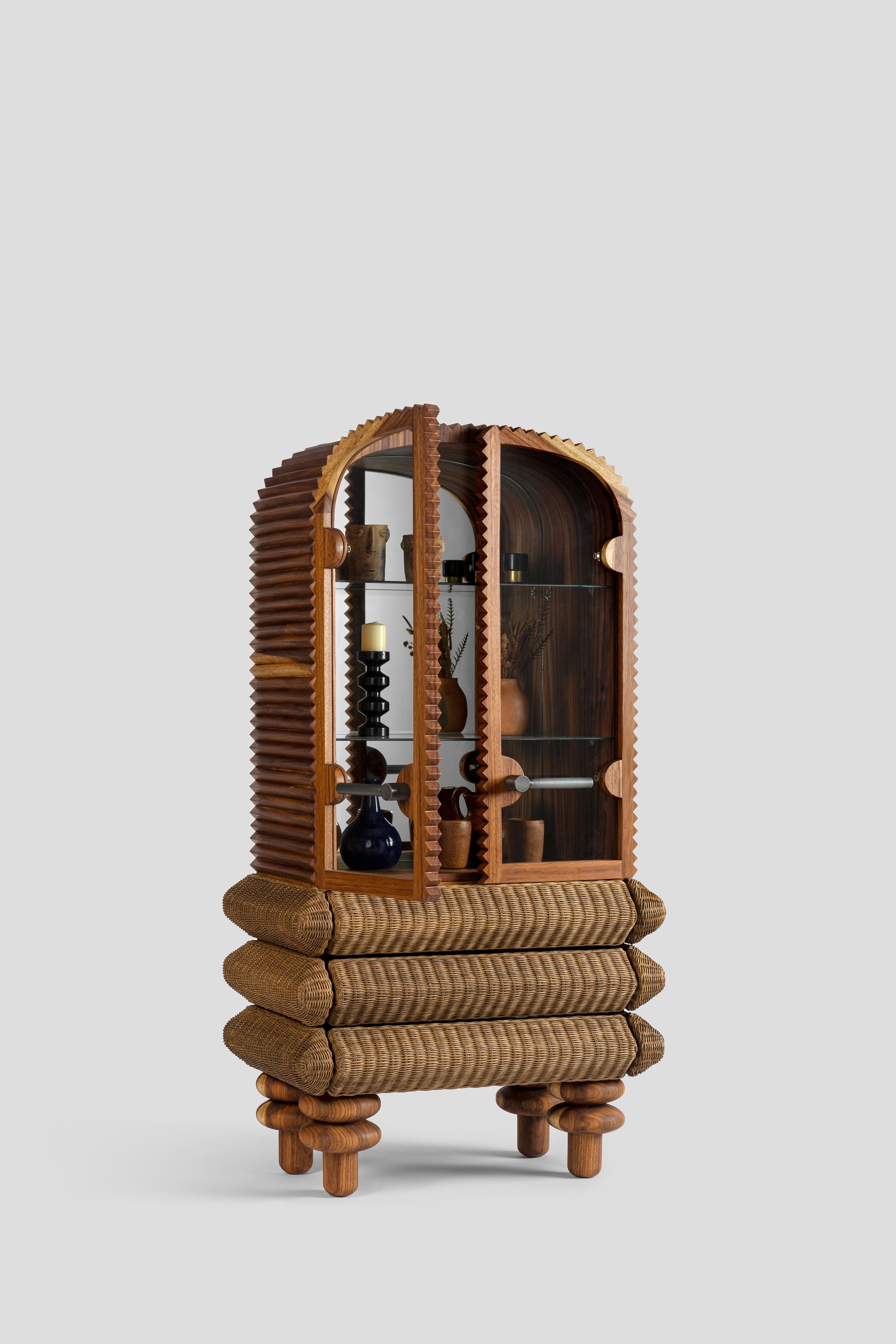 Vilma is a vertical display cabinet composed of two modules: a drawer unit covered with rattan fiber and a storage cabinet with solid huanacaxaxtle wood doors and glass shelves. The back of the cabinet is lined with mirror, which provides greater