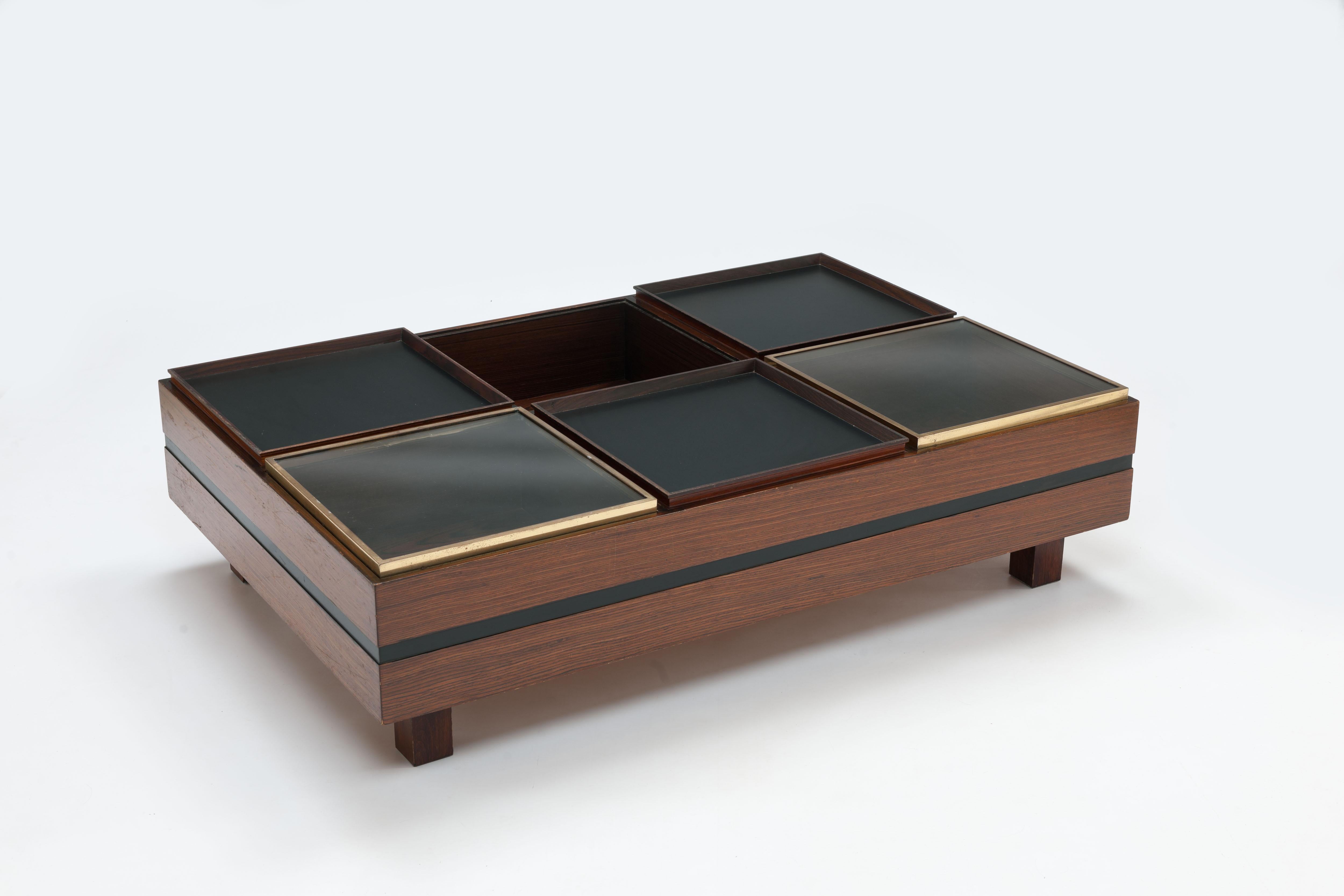 Luigi Sormani (Italy, 1932-2017)), 1960s coffee table divided into six deeper compartments with 5 'lids' and an open compartment. 
These 'lids' are three reversible trays - one side of wood, the other side of black laminate - and two transparent