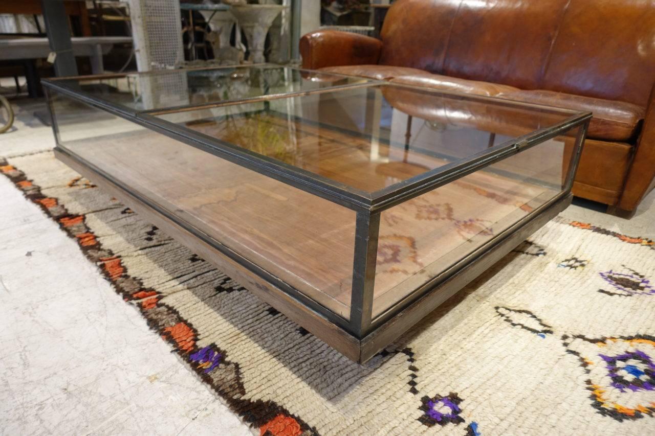 Super cool trolley / coffee table, in glass and dark brass frame. This handsome vintage double display case /montre has been creatively and tastefully converted to a smart coffee table / showcase on wheels. The large glass panes can open to one can