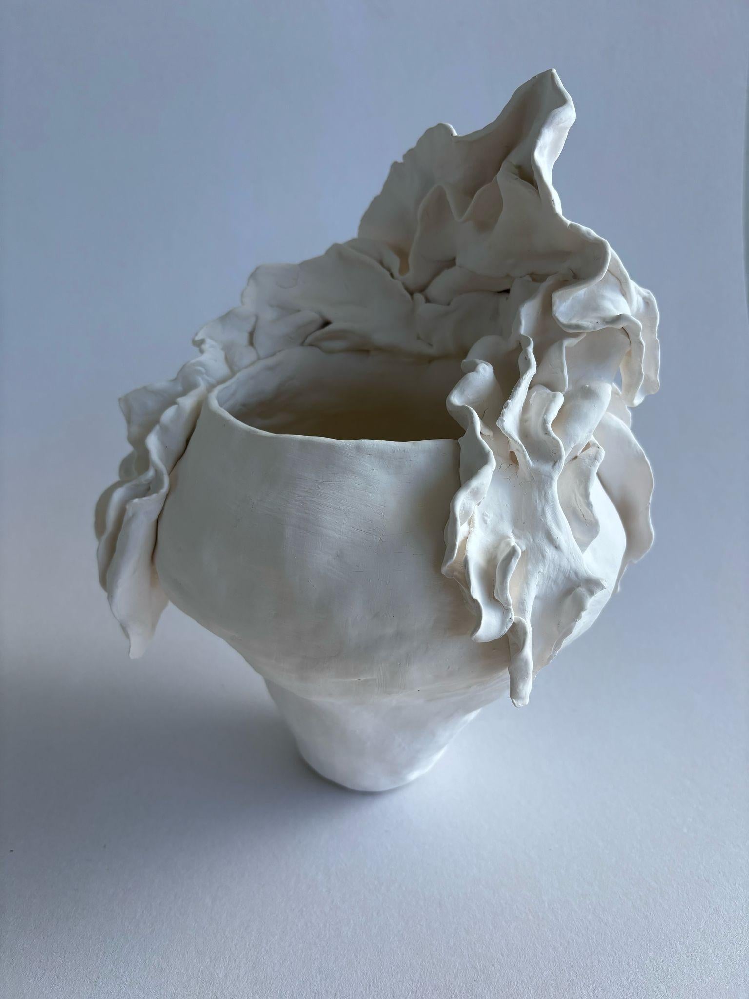 I sculpted this porcelain vase vessel in a free and dynamic manner. I named it “Dissolved in the Mist”, as it exists on the delicate boundary between reality and imagination. Its form is undefined, its lines swirl like an old memory fading away. It