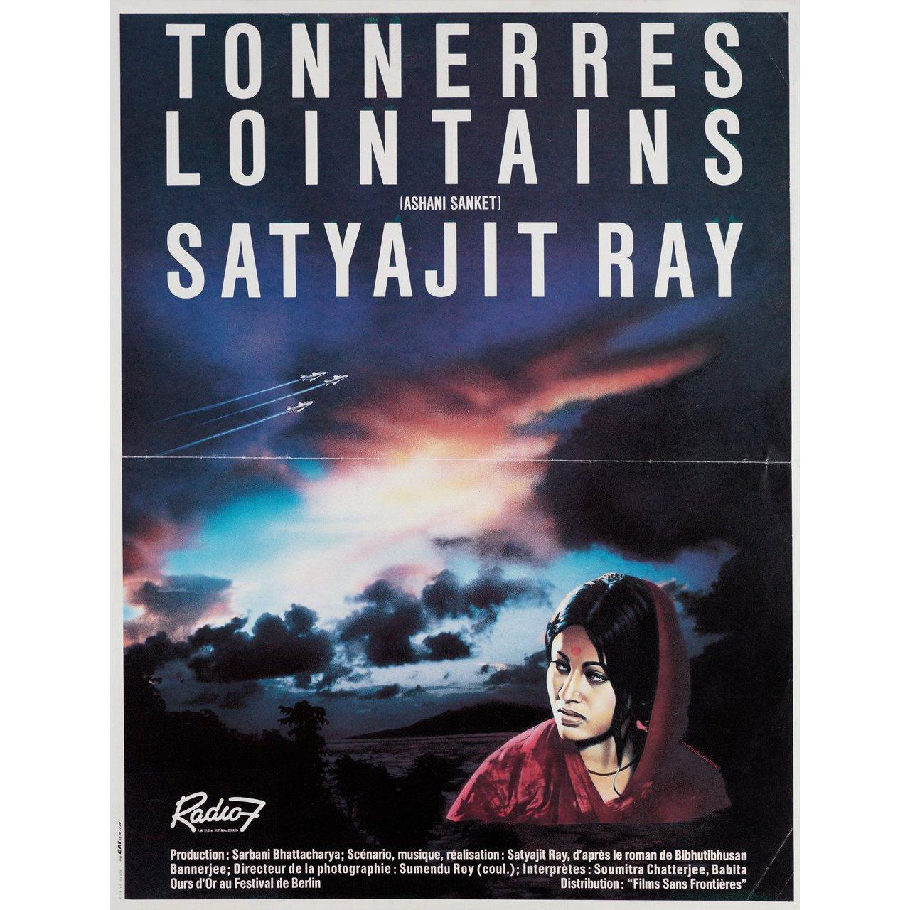 Original 1985 French petite poster for the first French theatrical release of the 1973 film Distant Thunder (Ashani Sanket) directed by Satyajit Ray with Soumitra Chatterjee / Babita Kapoor / Sandhya Roy / Chitra Banerjee. Very Good-Fine condition,