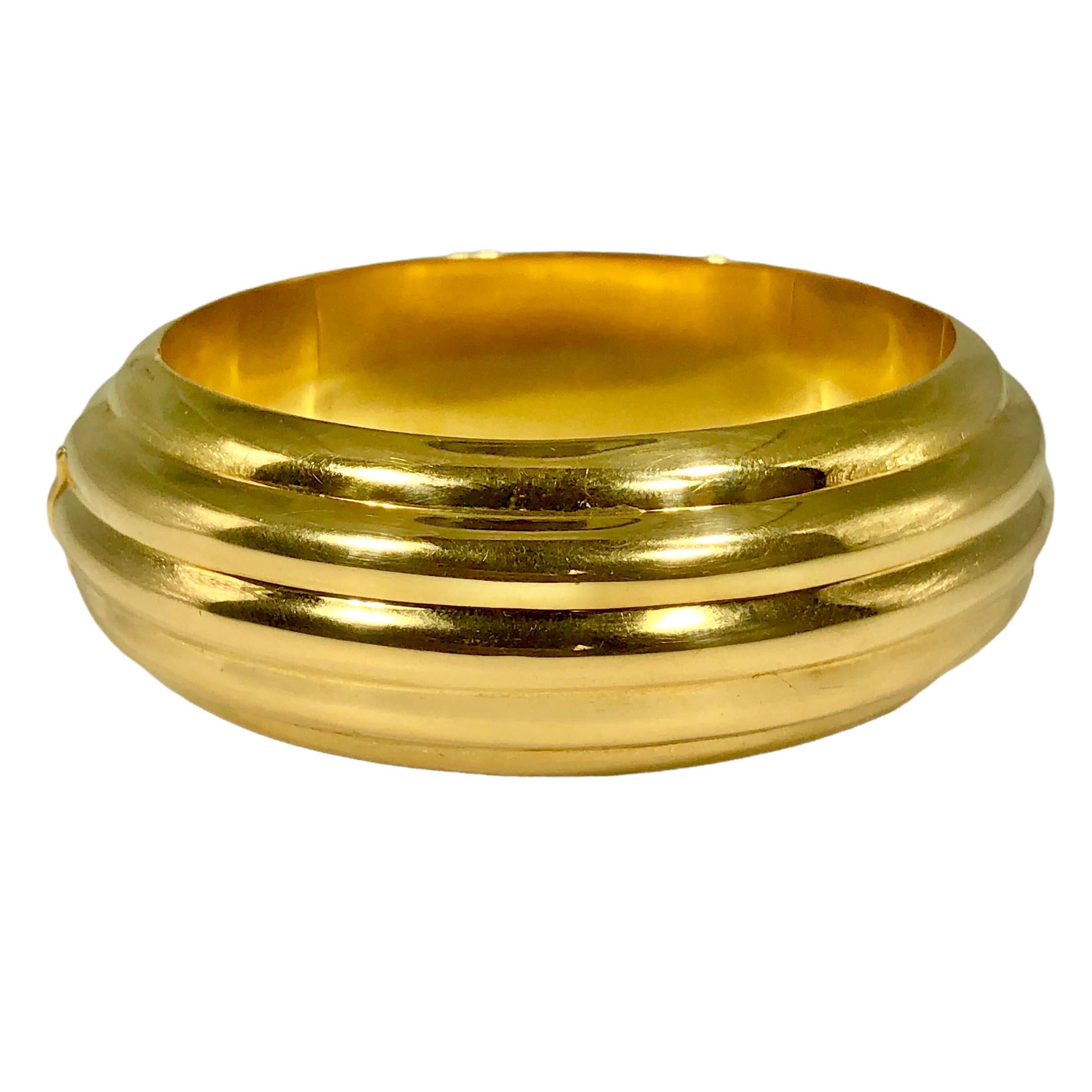 This pristine Late-20th Century, 18k yellow gold hinged cuff bracelet is certain to be a hit whenever it is worn. The bombe, fluted design is simple yet striking. The  quality is typical of the very best jewelry manufacturers. The bracelet measures