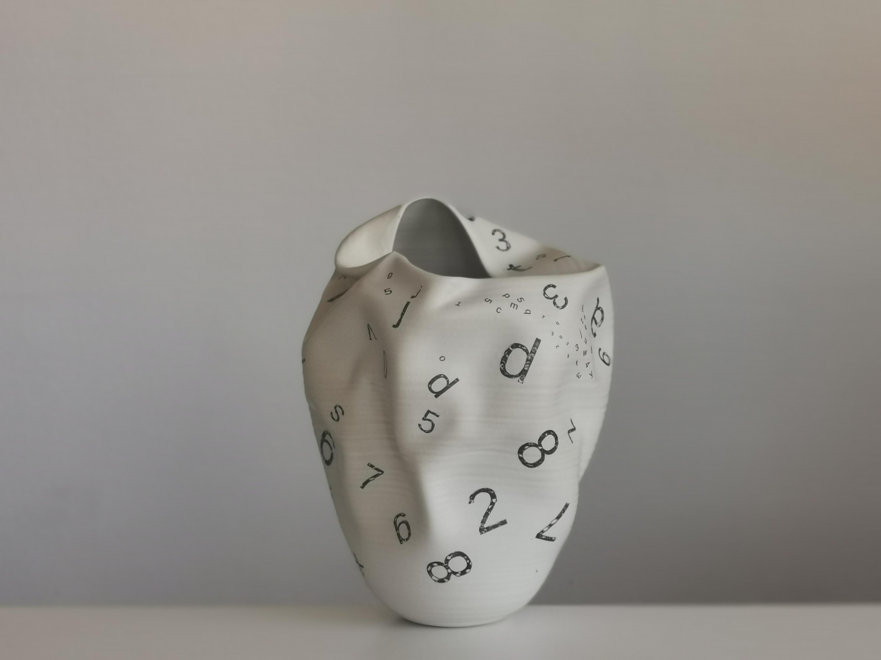 N. 82 white distorted form with letters and numbers. Sumptuous ceramic vessel from ceramic artist Nicholas Arroyave-Portela.

Materials, White St.Thomas clay, Stoneware glazes, Multi fired to cone 9 (1260 degrees).

Measures: H 38 cm W 30 cm D