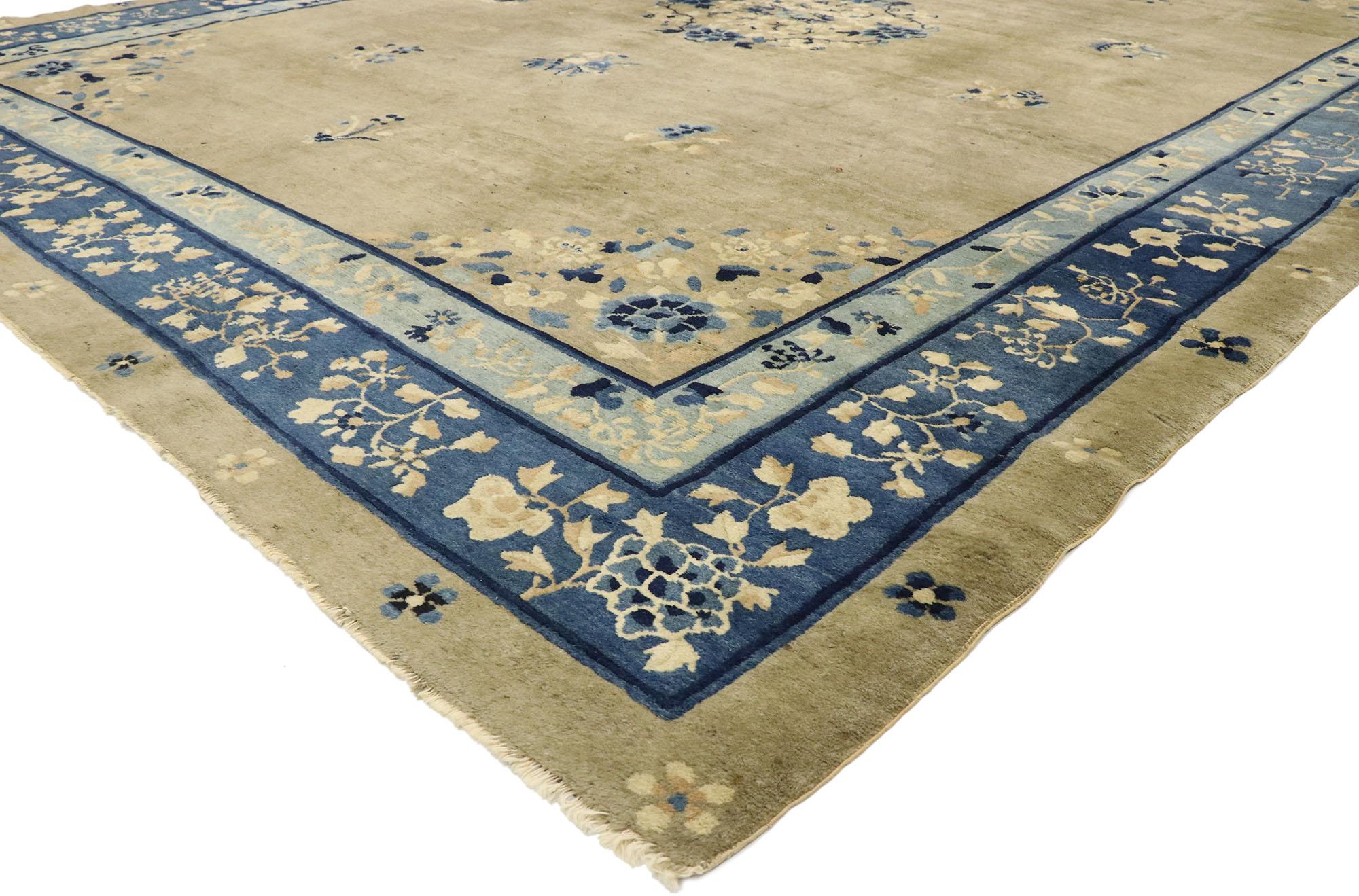 77510 distressed antique Chinese rug with romantic chinoiserie style. This hand knotted wool distressed antique Chinese Peking rug features a rounded open medallion decorated with a swirl of peonies and leafy tendrils floating in the center of an