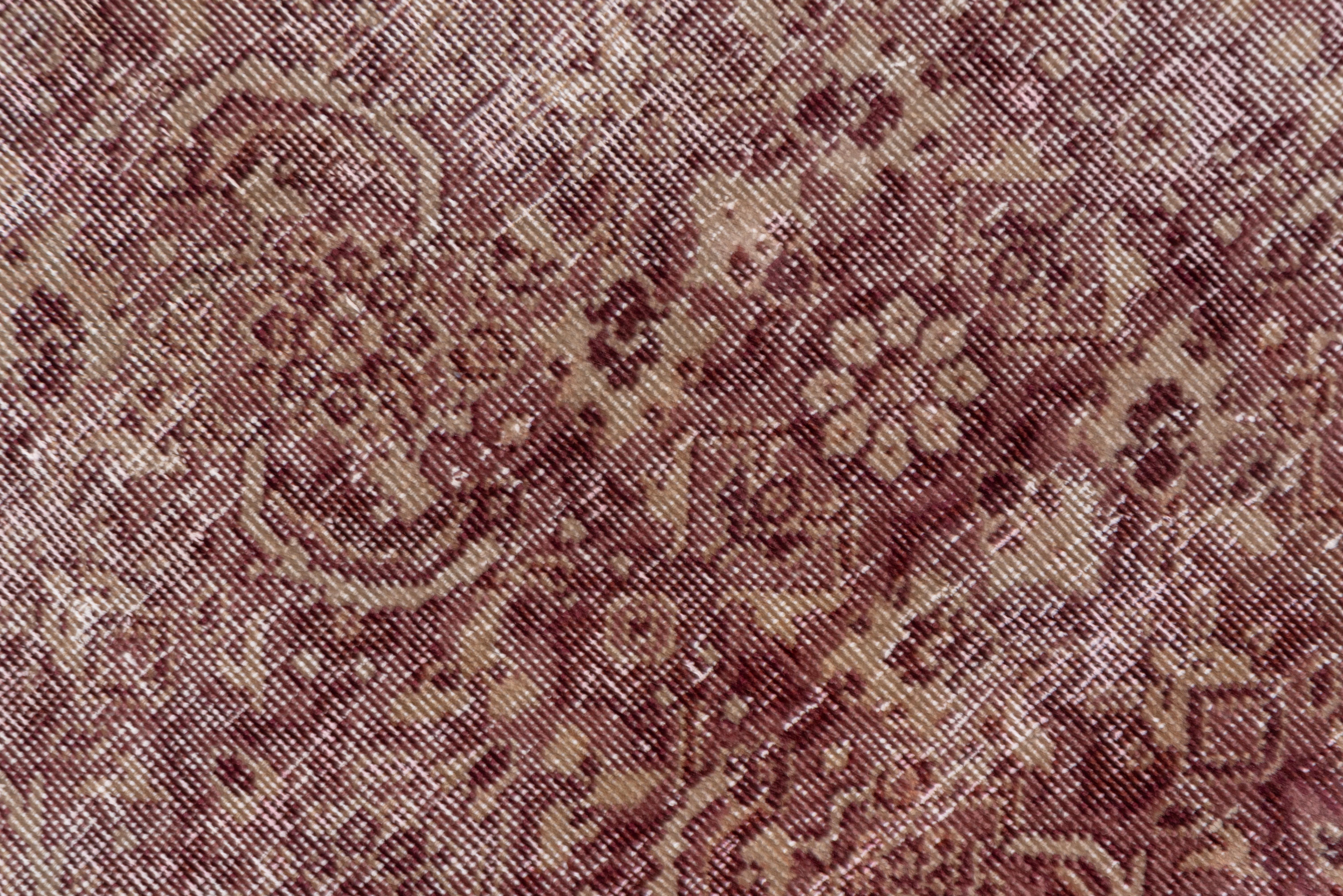 The distressed light wine burgundy field displays, where you can find it, an all-over Herati design, set within a light wine turtle palmette border.
