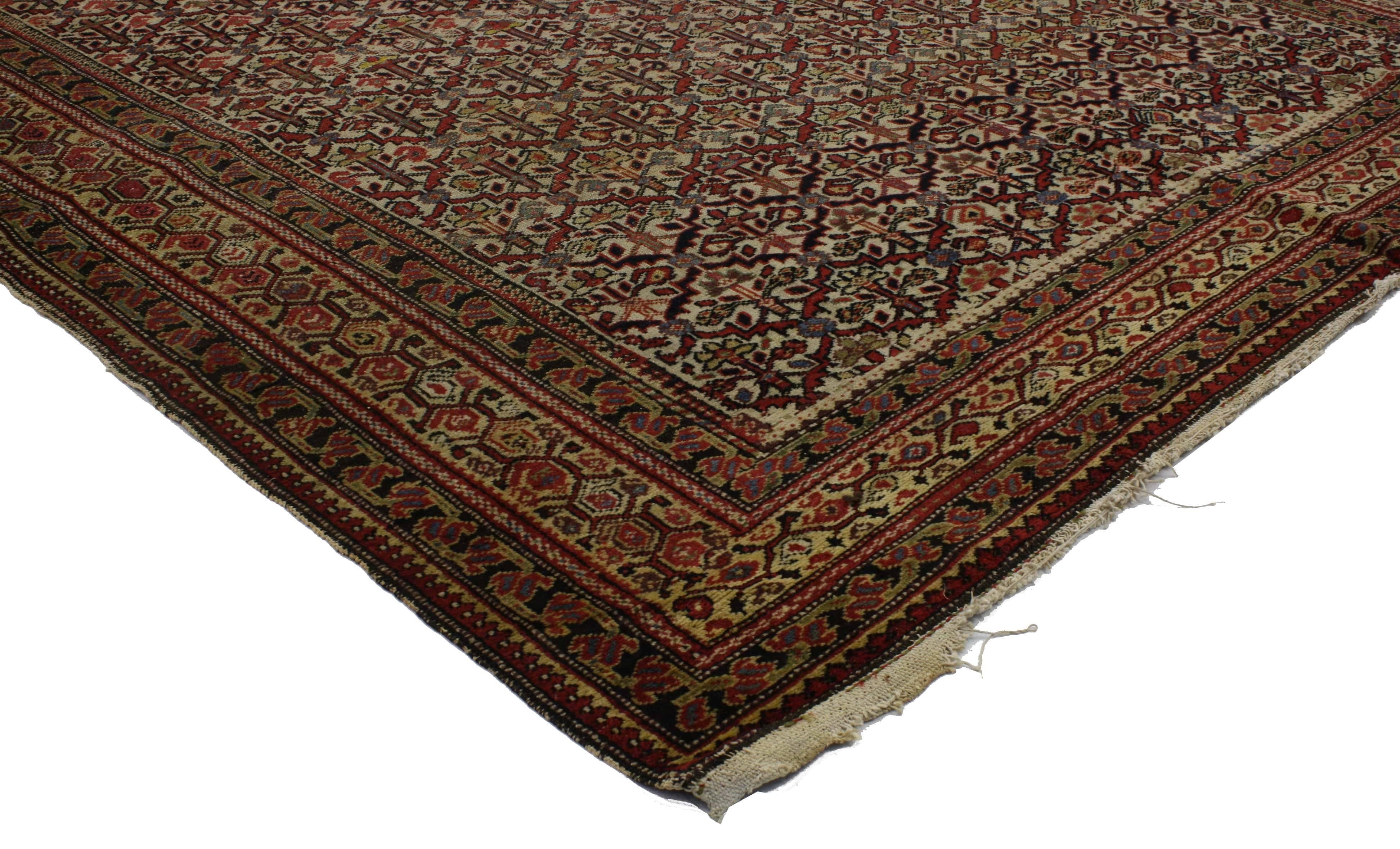 76694, distressed antique Malayer Persian area rug with industrial rustic Style. This hand knotted wool antique Persian Malayer rug features an all-over floral lattice pattern with gentle waves of abrash. A honeycomb boteh main border echoes the