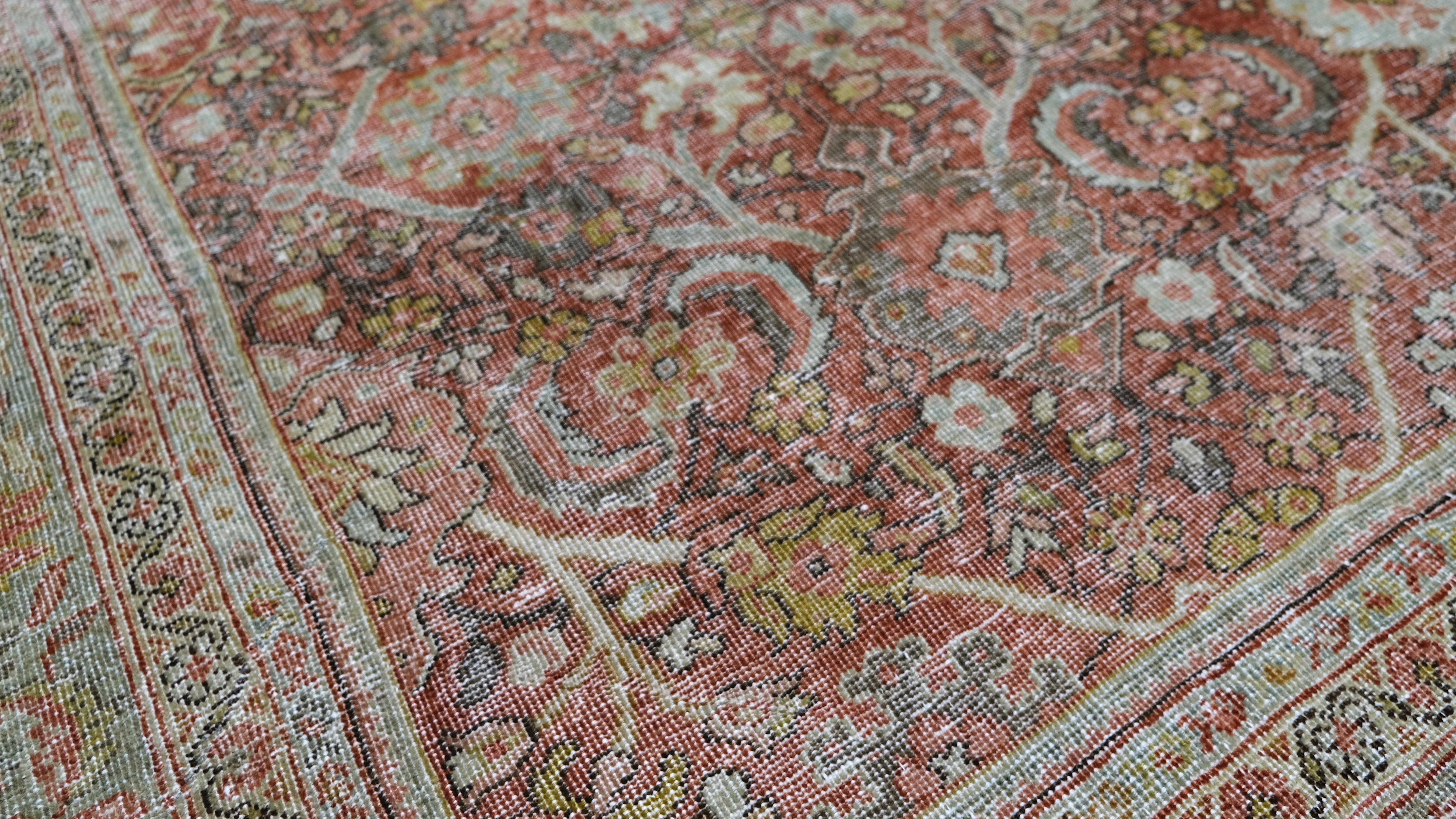 Dieser exquisite antike handgeknüpfte Wollteppich ist eine zeitlose Darstellung traditioneller Kunst und Handwerkskunst. Mit seinem komplizierten Muster, das von einem komplexen Gitter aus Ranken und Blüten umgeben ist, verkörpert dieser Teppich die