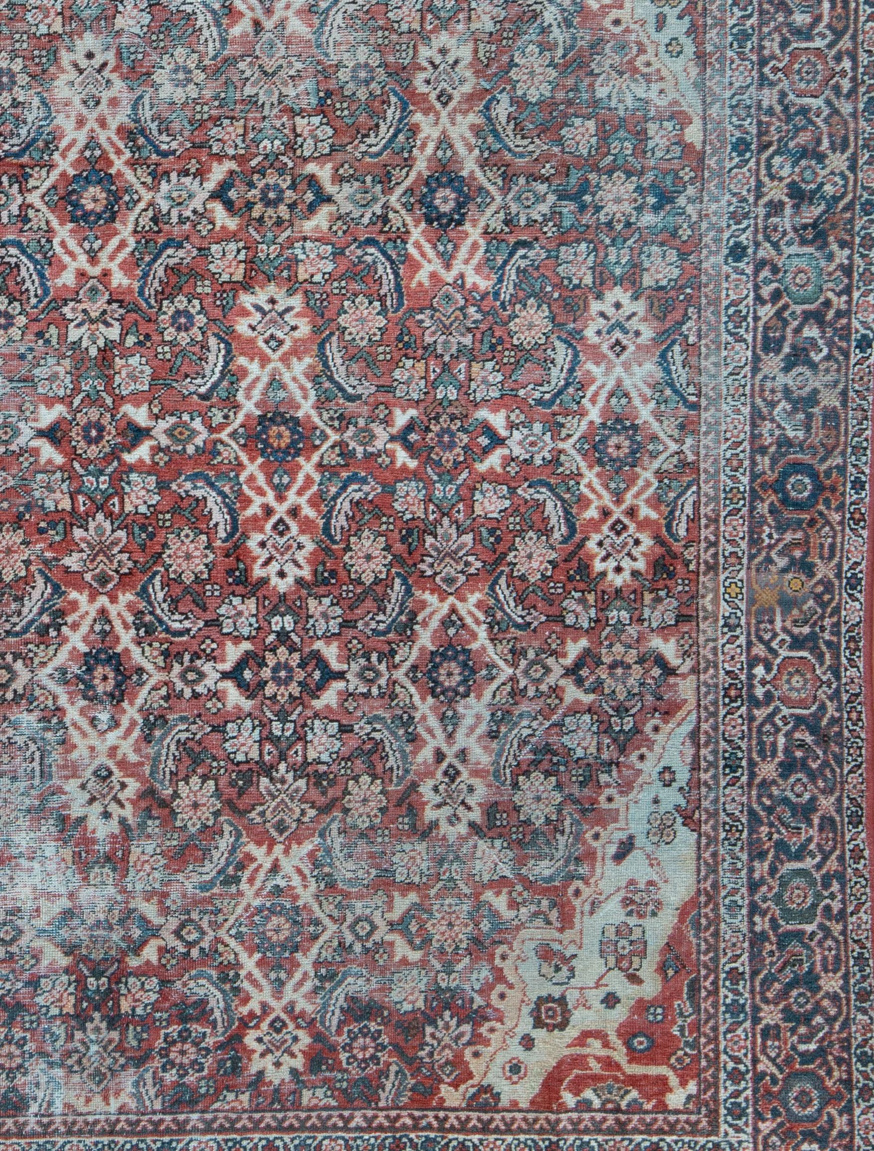 A turn of the century Persian Mahal and great example of a village weaving. A soft red field color with an all over design and corner pockets in ivory, jade green and indigo blue. A natural, worn patina and is all secured - No holes or patches and