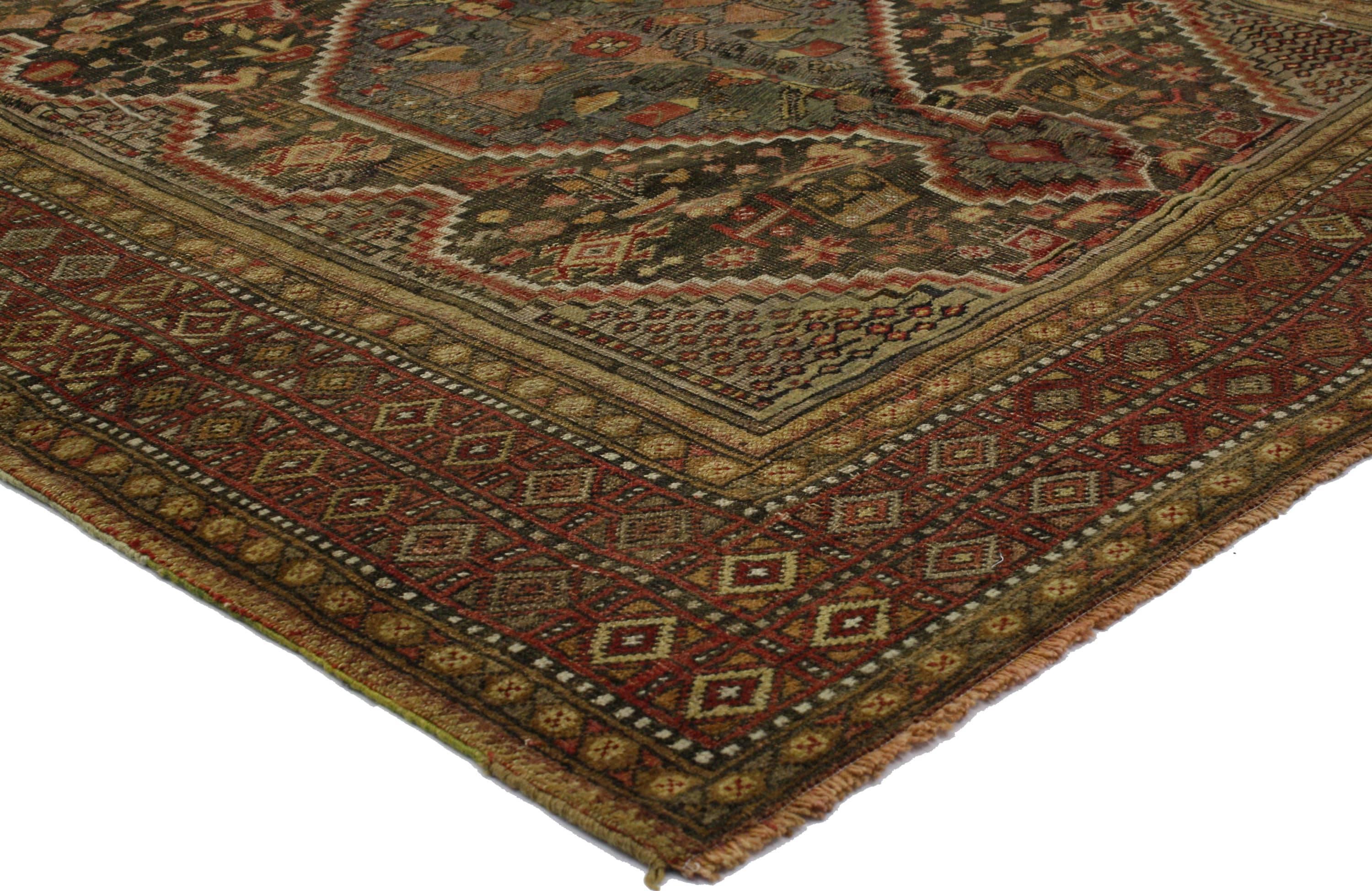 51558 Distressed Antique Persian Shiraz rug with Rustic Tribal style. This hand knotted wool distressed antique Persian Shiraz rug features a stepped pole medallion with anchor pendants floating on an abrashed field. The field is scattered with a
