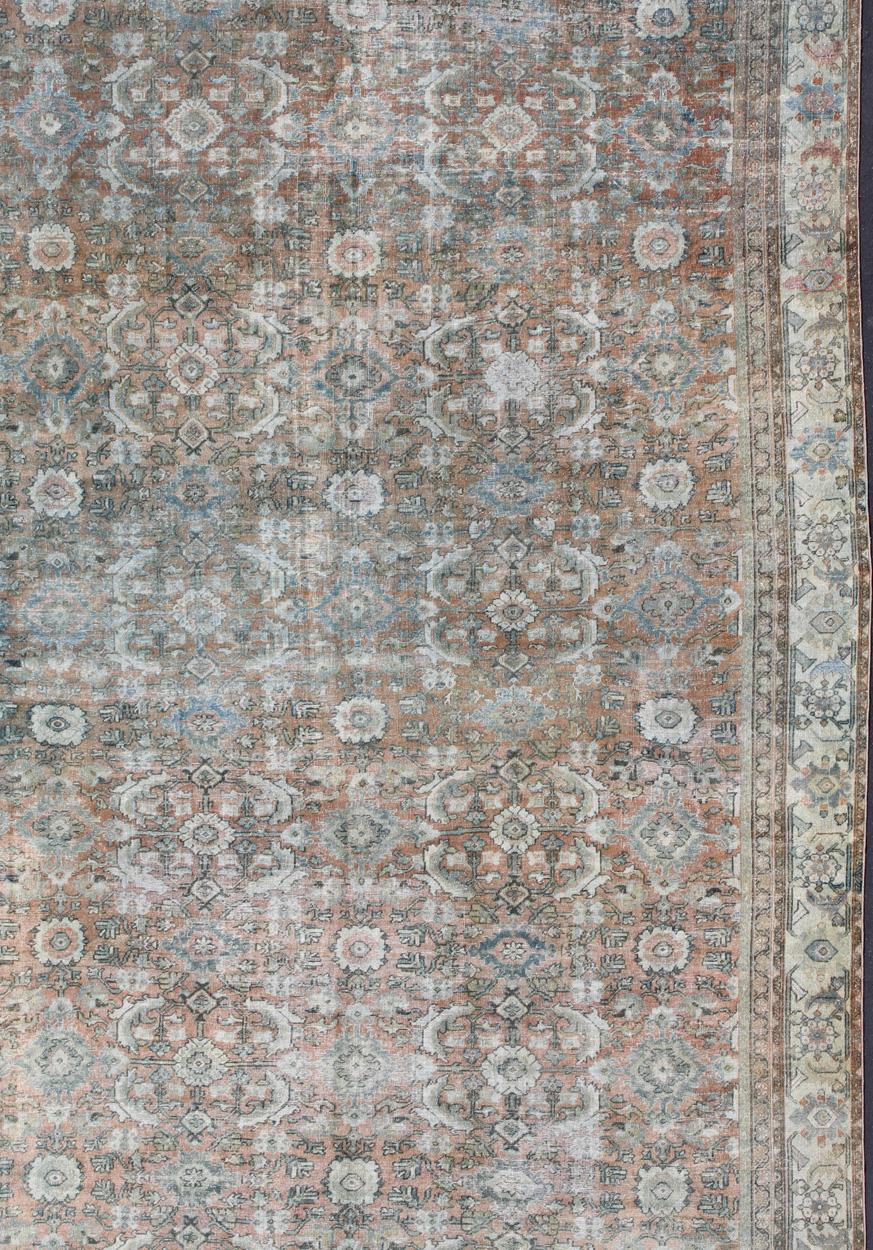 Large Mahal antique rug from with all-over geometric design, Arts/ rug S12-0618, country of origin / type: Iran / Sultanabad, circa 1920s wit faded red background, ivory and blue border and multi colors. distressed antique Persian Sultanabad