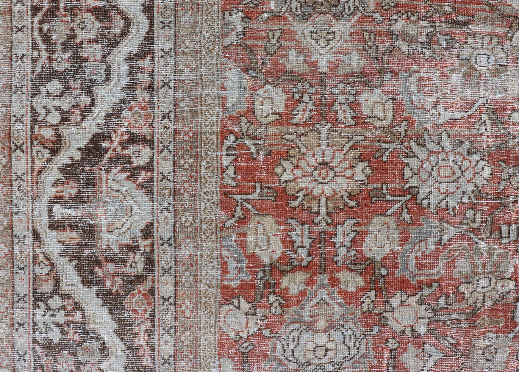 This antique Persian Sultanabad rug an all-over sub-geometric floral design rendered in orange and earthy tones, set upon an orange background. A complementary, multi-tiered border encompasses the entirety of the piece; making it a marvelous fit for
