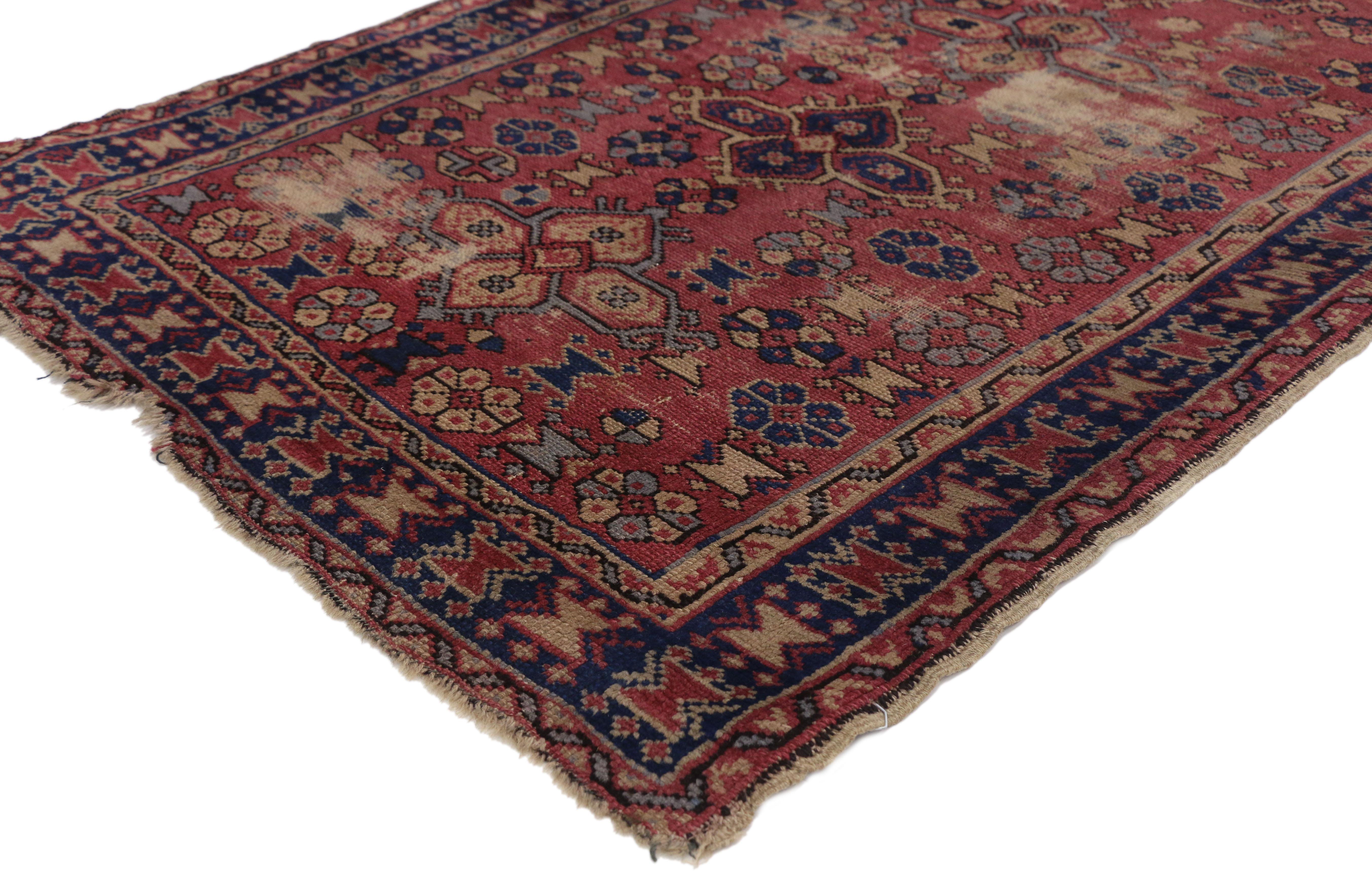 71057, distressed antique Turkish Sparta rug with Industrial style. This hand knotted wool distressed antique Turkish Sparta rug features an all-over pattern composed of four petal amulets with latch-hook edges, roundel rosettes, and head hand