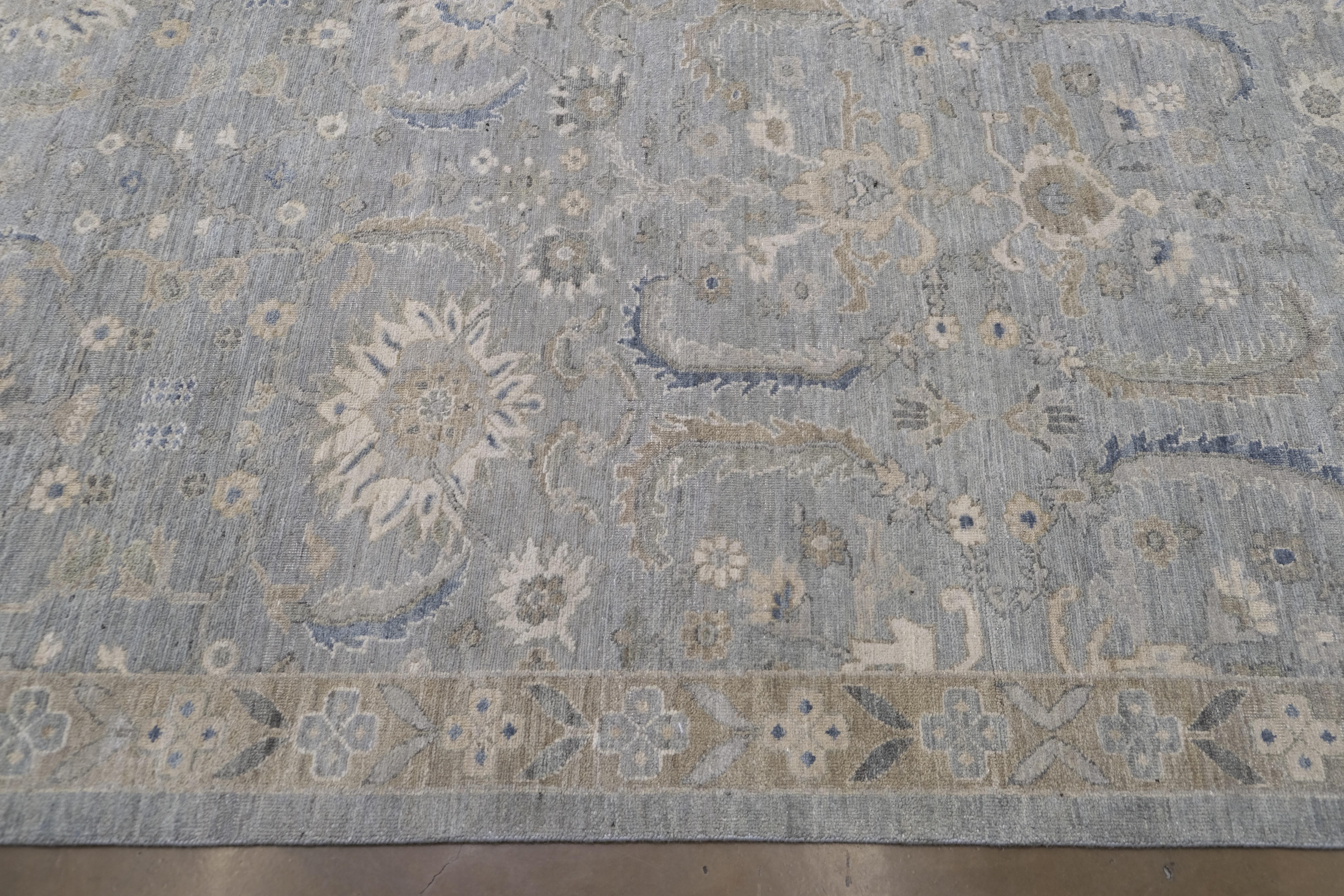 Questo tappeto oversize in lana annodato a mano incarna un'eleganza senza tempo con il suo motivo tabriz di ispirazione antica, caratterizzato da intricati motivi botanici in morbide tonalità blu e beige. Questo tappeto, che ricorda i classici