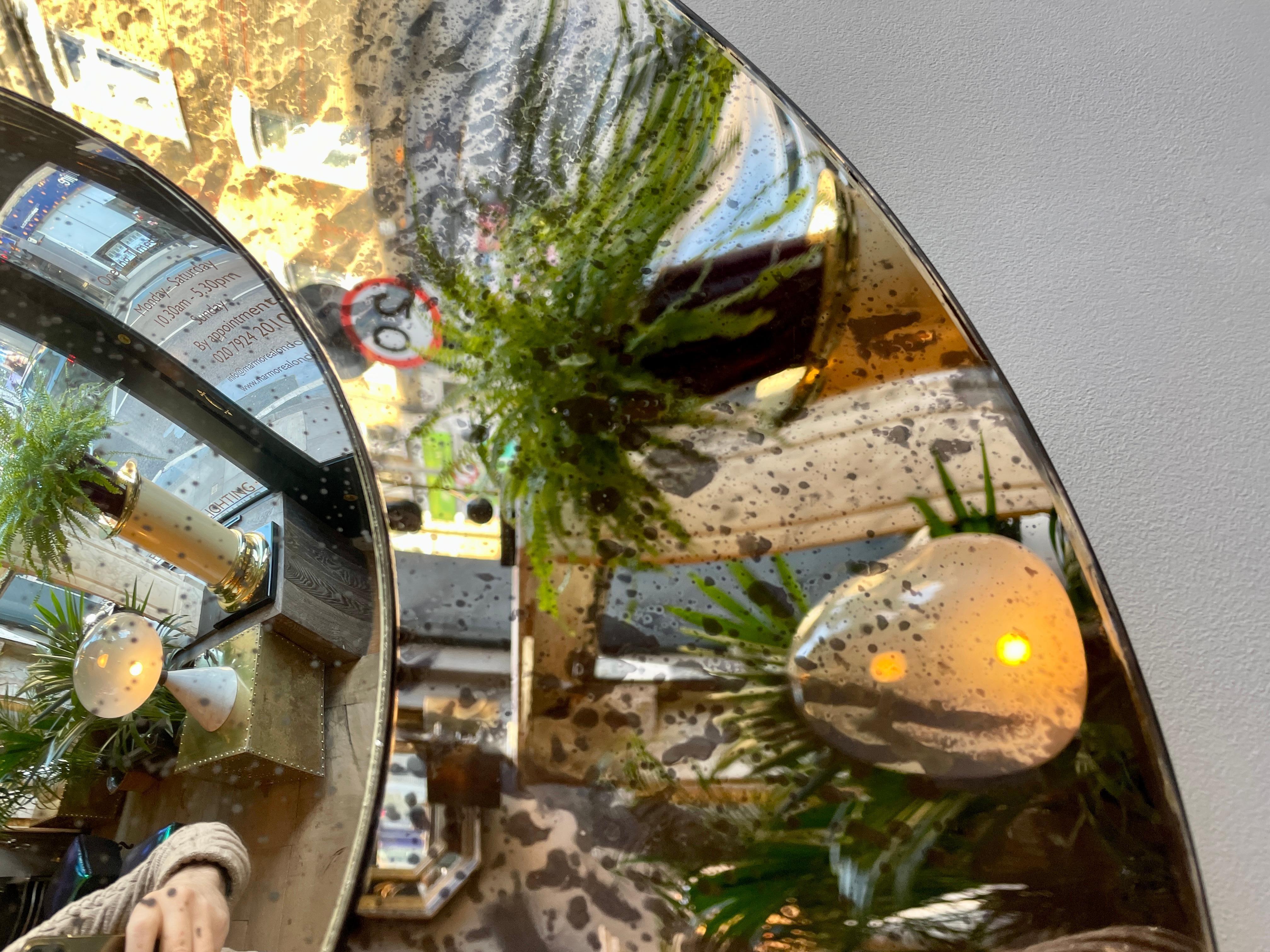 A concave mirror in distressed bronze colour with a silver distressed convex mirror to centre. Frameless, held in place by 4 clips and secured at he back with a circular fitting and built in hook for hanging.