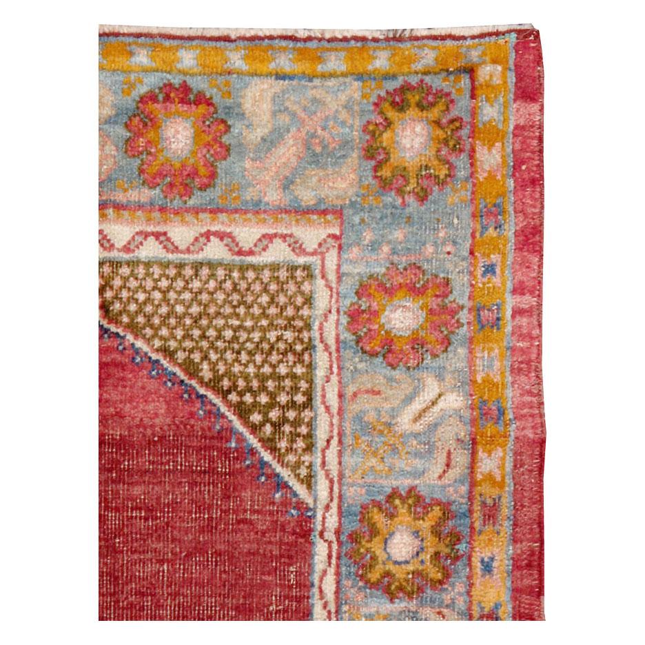 A handmade antique Turkish Oushak rug with a weathered and distressed appeal consistent with its age, but otherwise in very strong and durable condition. The crimson red and white polka dot green field are separated by a white and blue archway. The