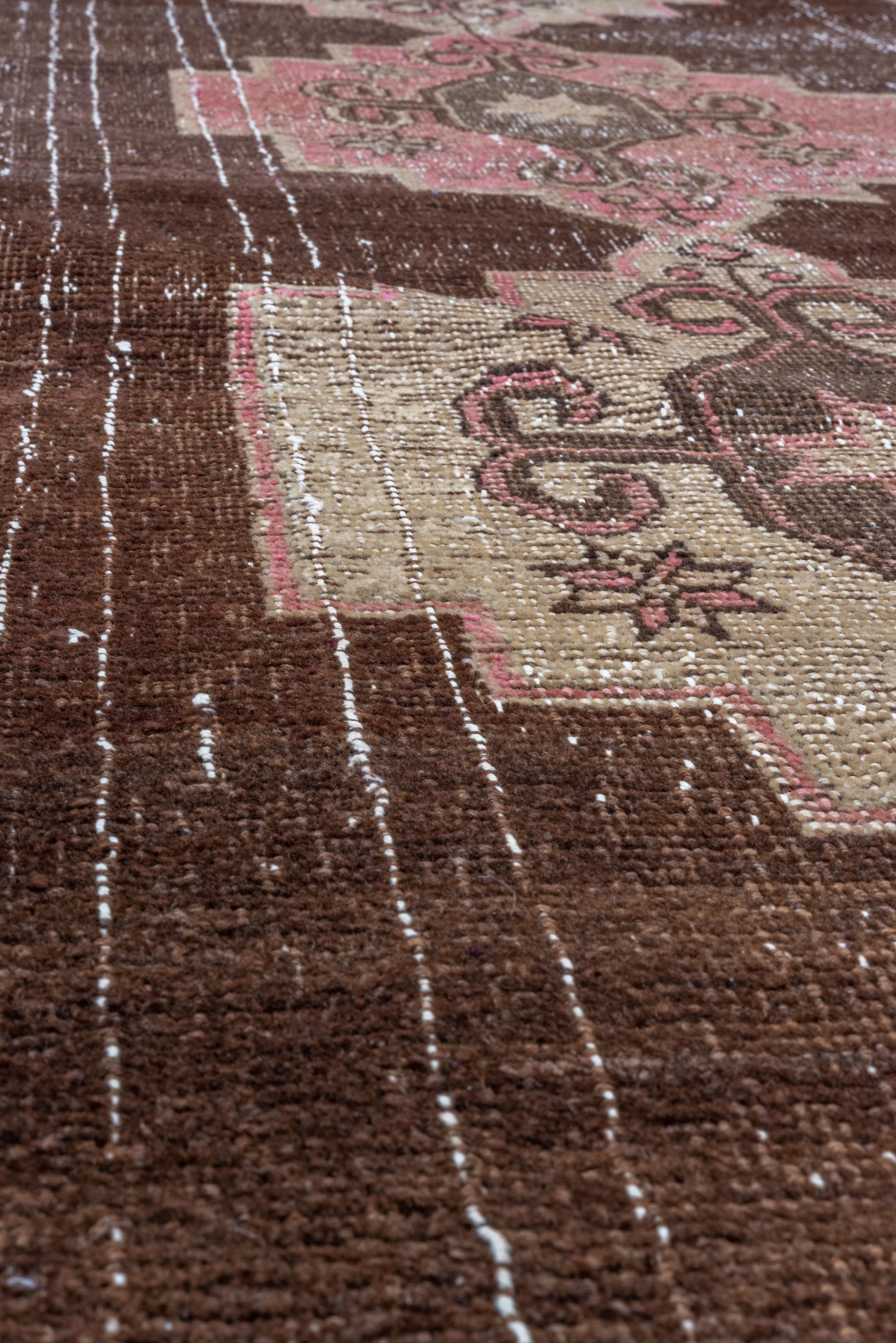 Faded pink medallions float on a deep brown field in this vintage-washed Turkish Kars. A moody and soft statement piece.