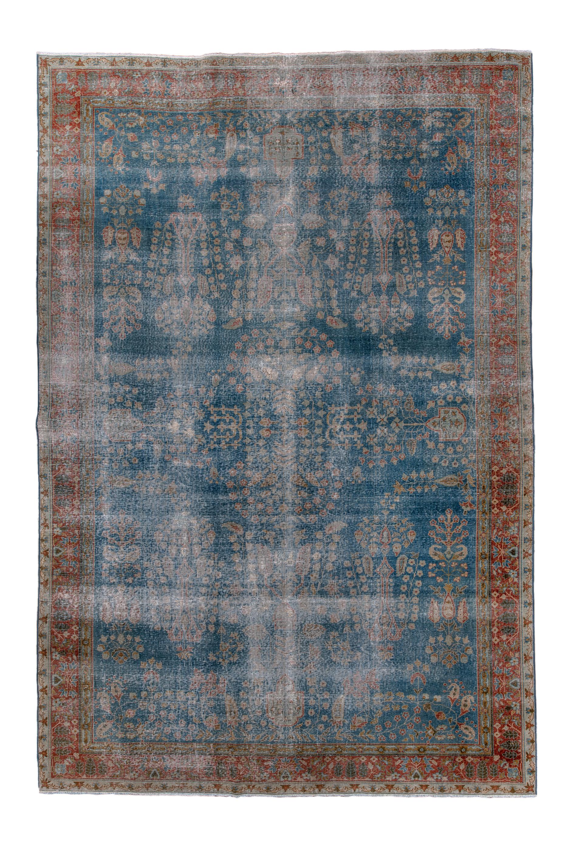 This distressed but still noble large scatter rug shows a royal blue field comfortably covered with detached floral sprays in the “American Sarouk” manner. The sprays are detailed in cream, stray and pistachio.  There are a few small botehs in the