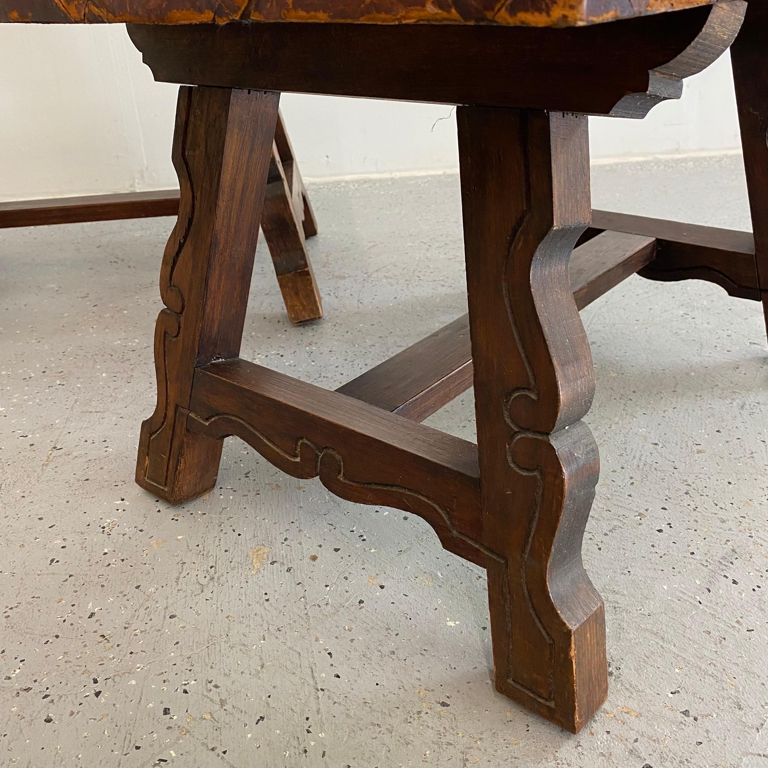 Likely European, maybe Belgian, small scale side tables. Simple scroll design with carved hardwood frame and leather top. Each show heavy wear but have a great look. Distressed but structurally sound. 

Free Shipping in the continental US.