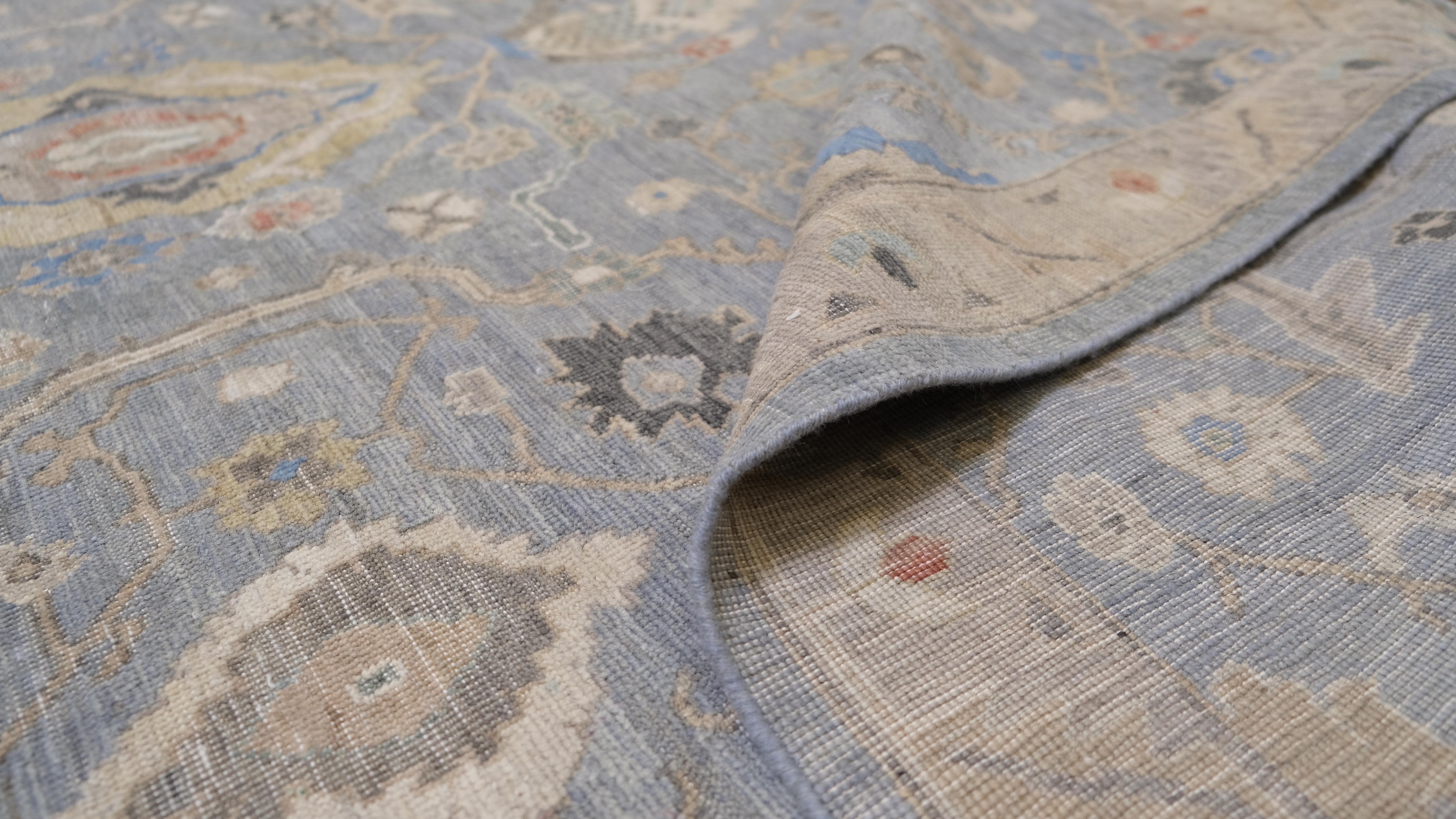 Bringen Sie Eleganz in Ihr Zuhause mit diesem exquisiten, handgeknüpften Wollteppich mit klassisch inspiriertem Design. Dieser luxuriöse Teppich zeigt komplizierte florale und geometrische Motive vor einem blauen Hintergrund, die durch Akzente in