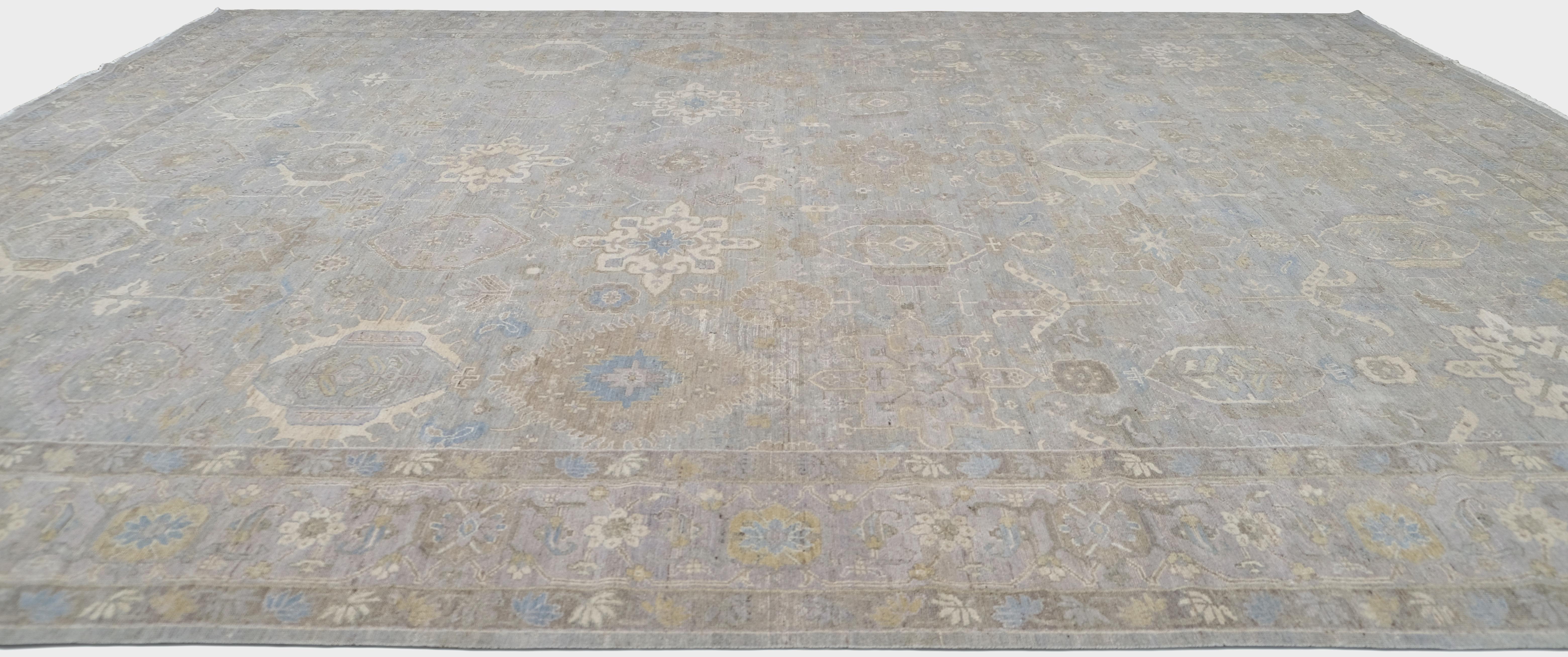 Verschönern Sie Ihren Wohnraum mit der exquisiten Handwerkskunst dieses handgeknüpften Wollteppichs. Mit seinem raffinierten hellgrauen Hintergrund und den komplizierten floralen und geometrischen Motiven in Elfenbein-, Beige- und Blautönen strahlt