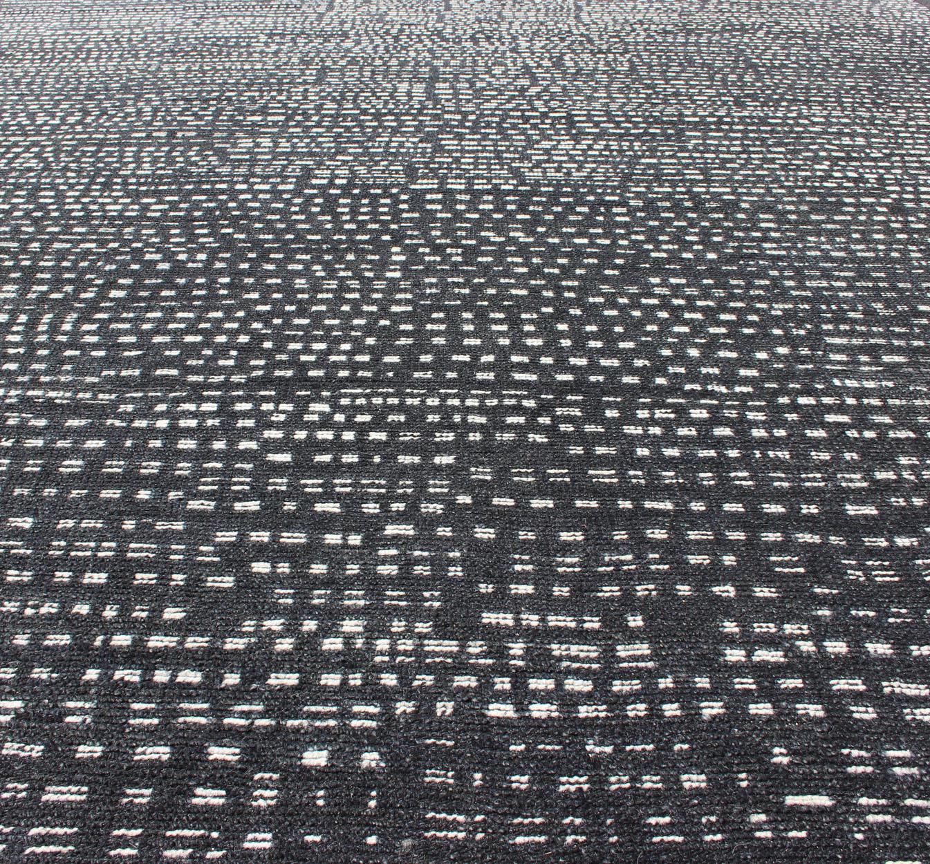 Distressed Modern Indian Wool Area Rug in Charcoal And White 
 Measures 9'0 x 11'11 
This modern casual was hand-knotted in India during the 2010s. The background is a dark gray, while the design is a simple white wool intertwined sporadically,