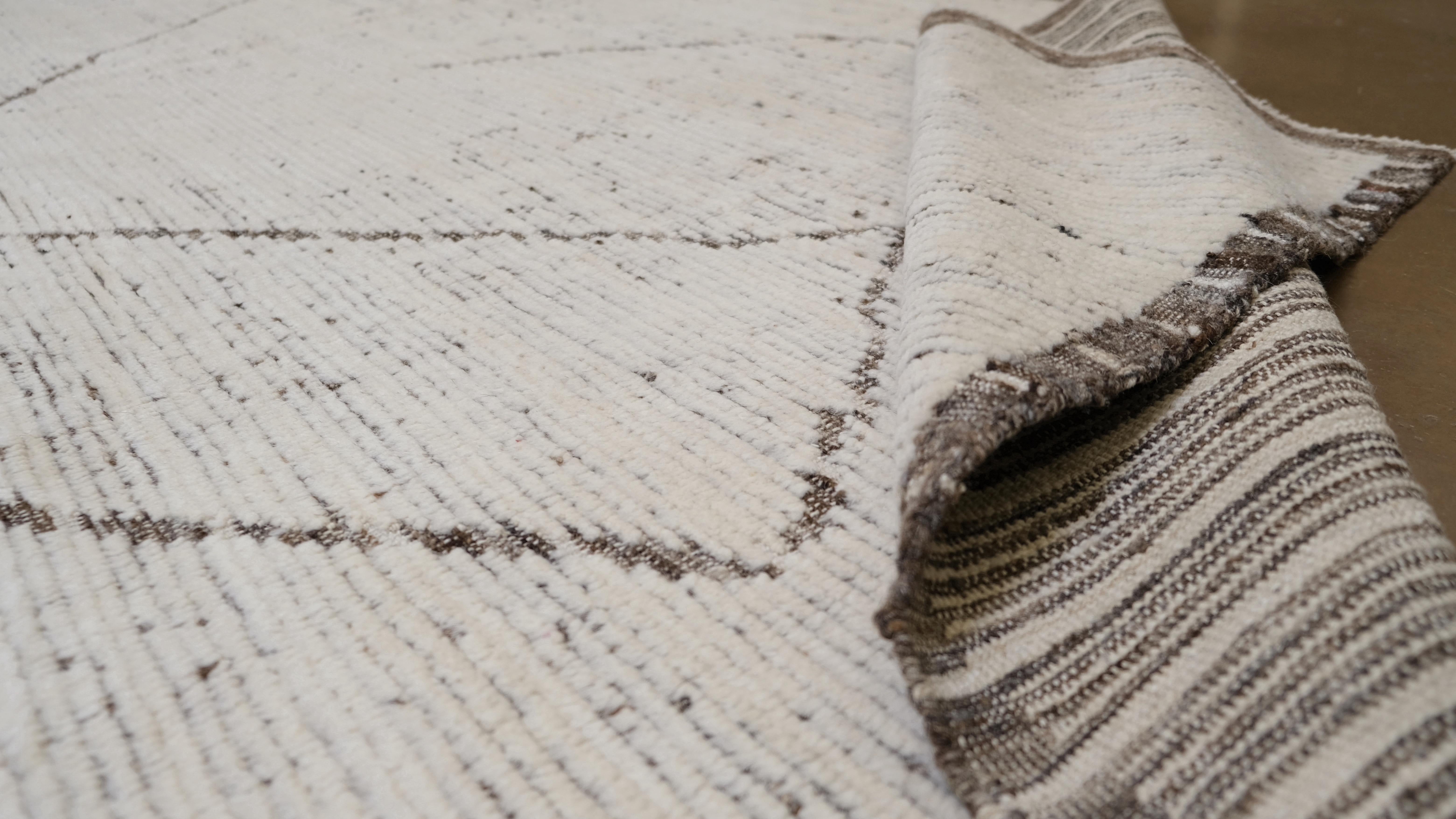 Un design minimaliste et sophistiqué. Présentant des lignes géométriques abstraites dans un contraste subtil sur un fond neutre, ce tapis offre une esthétique moderne et artistique qui s'intègre parfaitement aux intérieurs contemporains ou