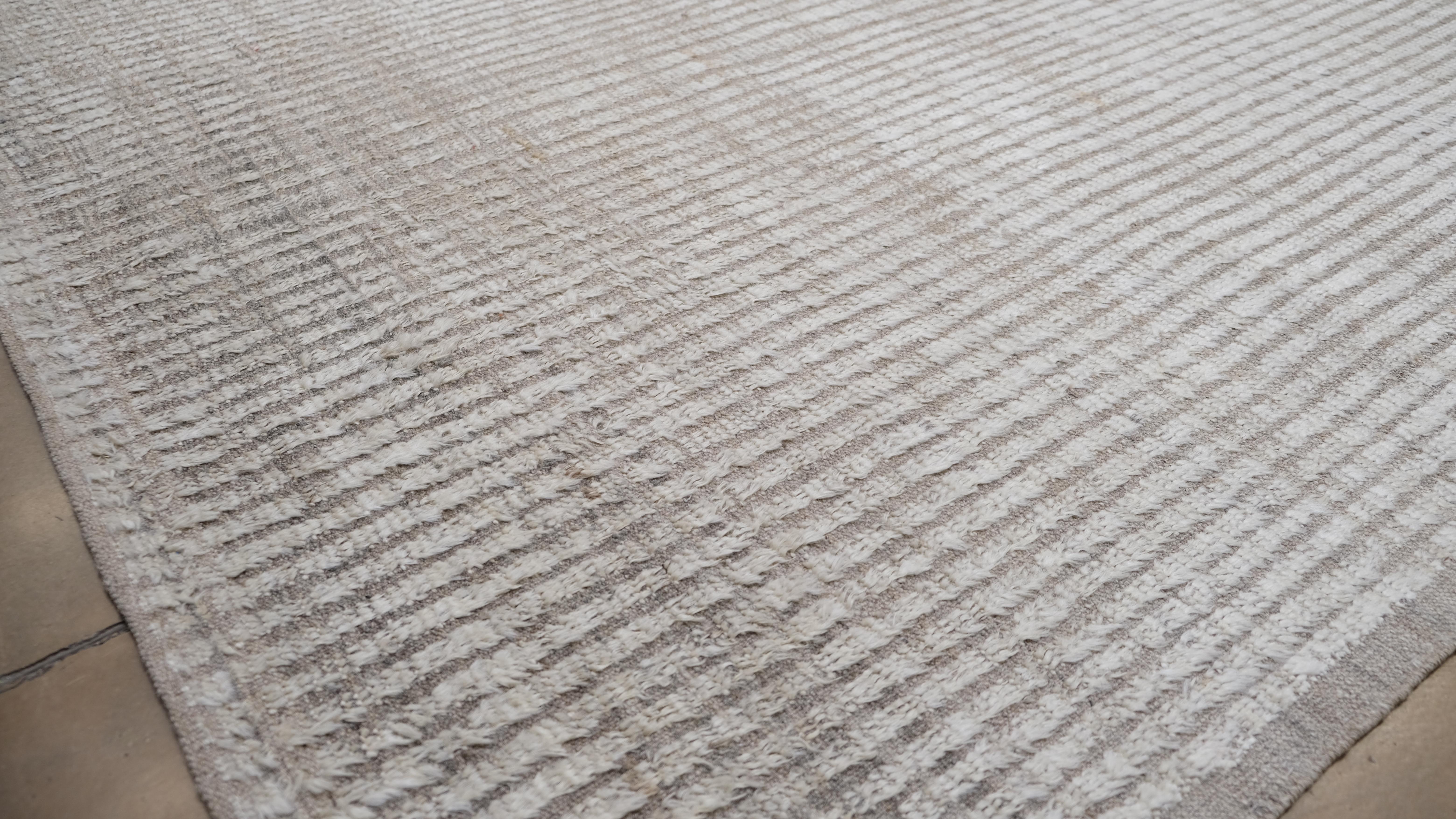 Elevate your interior with the understated elegance of this hand-knotted wool rug. Featuring soft neutral tones, this rug is the epitome of minimalist sophistication, perfect for both modern and transitional decor styles.

Key Features:
Origin: