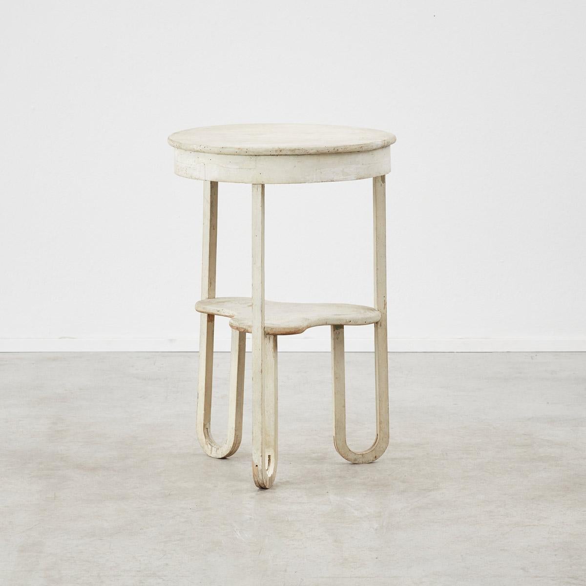 Elegant forms and shapes interlink to form this fun  chalk painted  wooden side table. The distressed paint effect appears as a textured matte lime wash, giving it a weathered look. Great functionality as a tall side table or hall table.