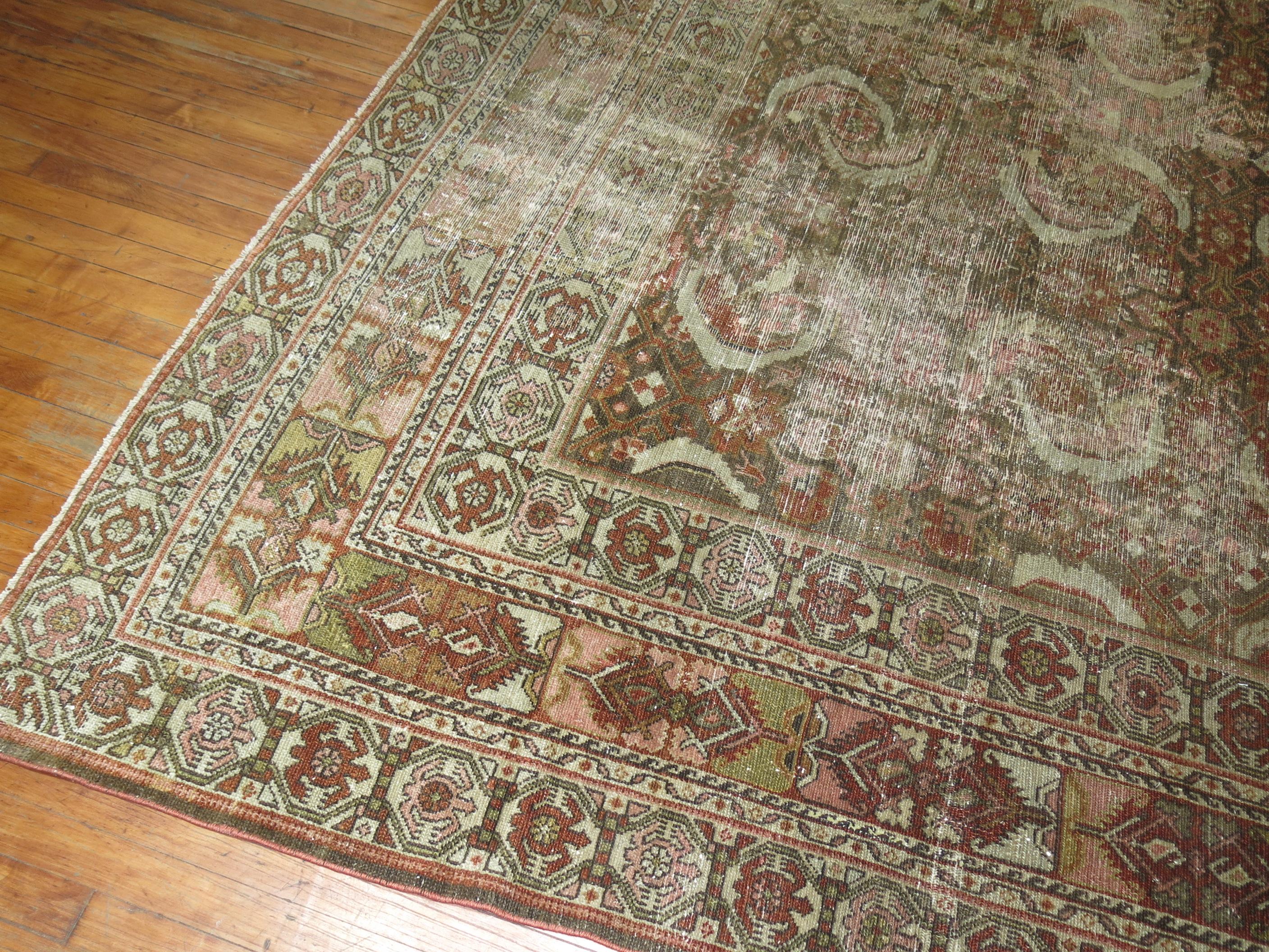 A distressed room size Persian Malayer rug from the early 20th century.