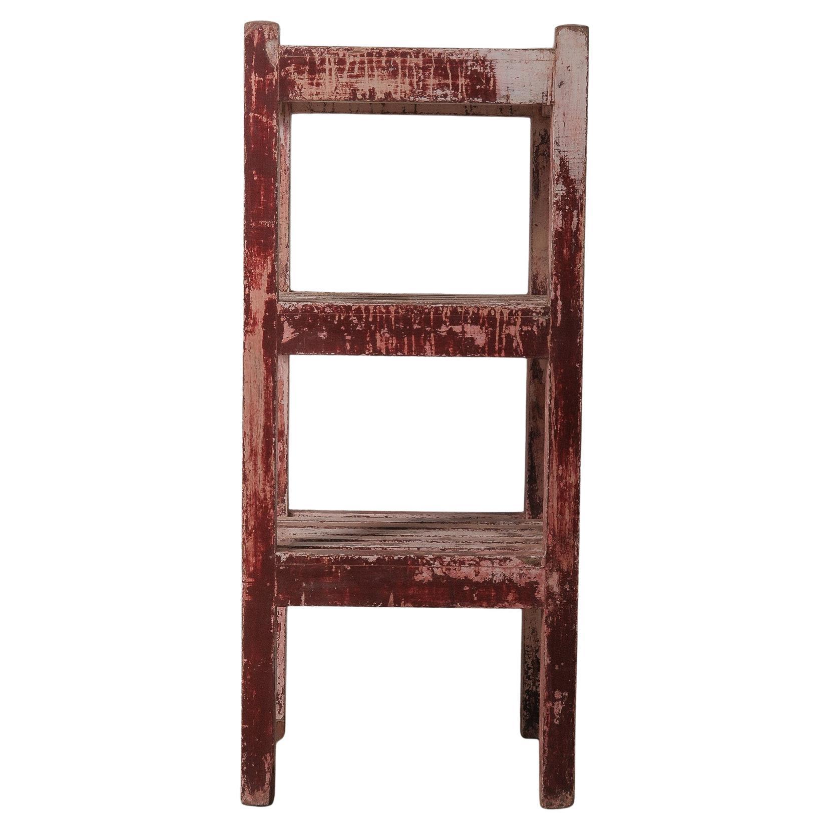 Distressed Red Wooden Shelf with Layered Patina