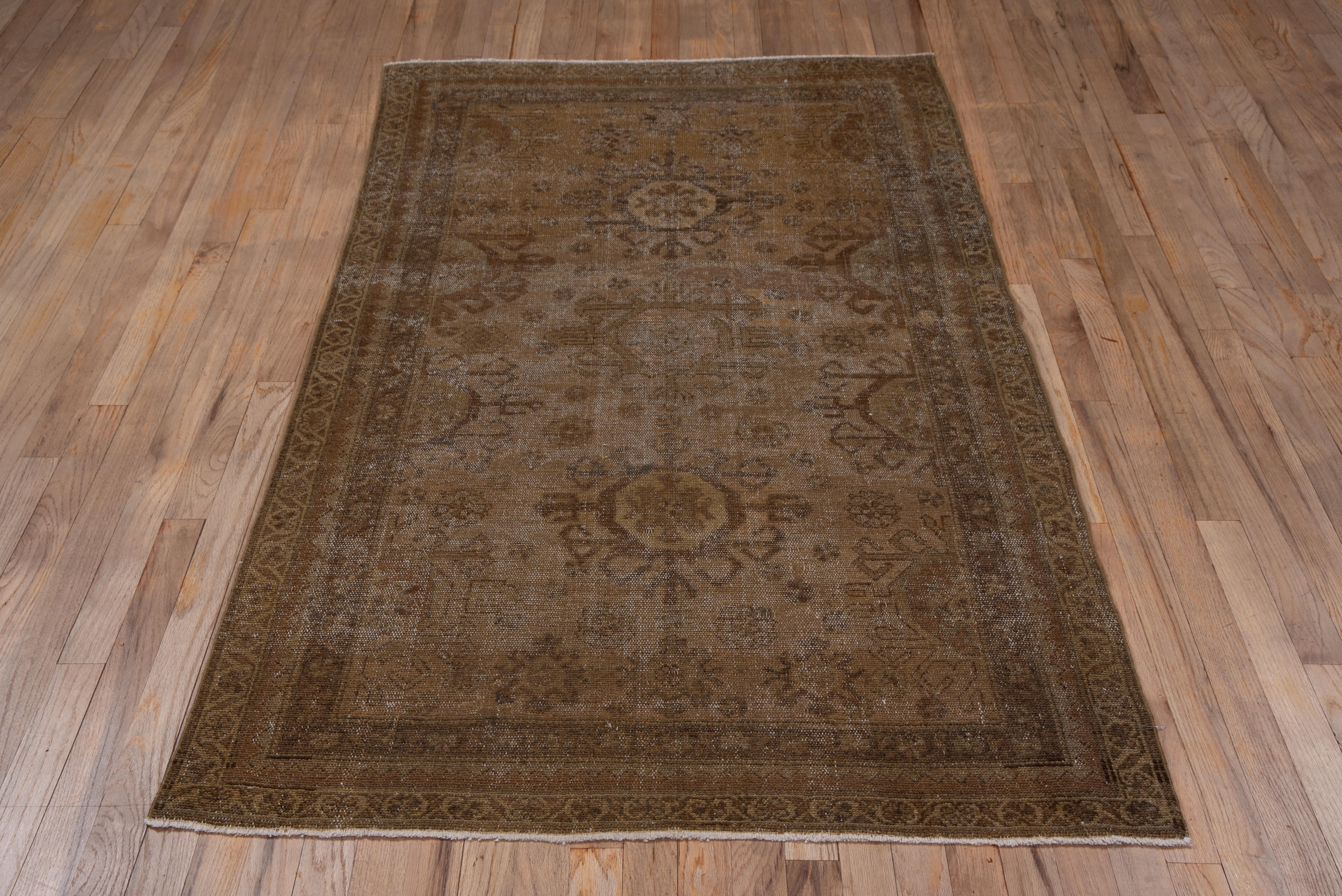This distressed, earth-tone scatter features a light brown-buff field with three hooked octagons in rust, straw and camel, with fractional medallions along the sides.