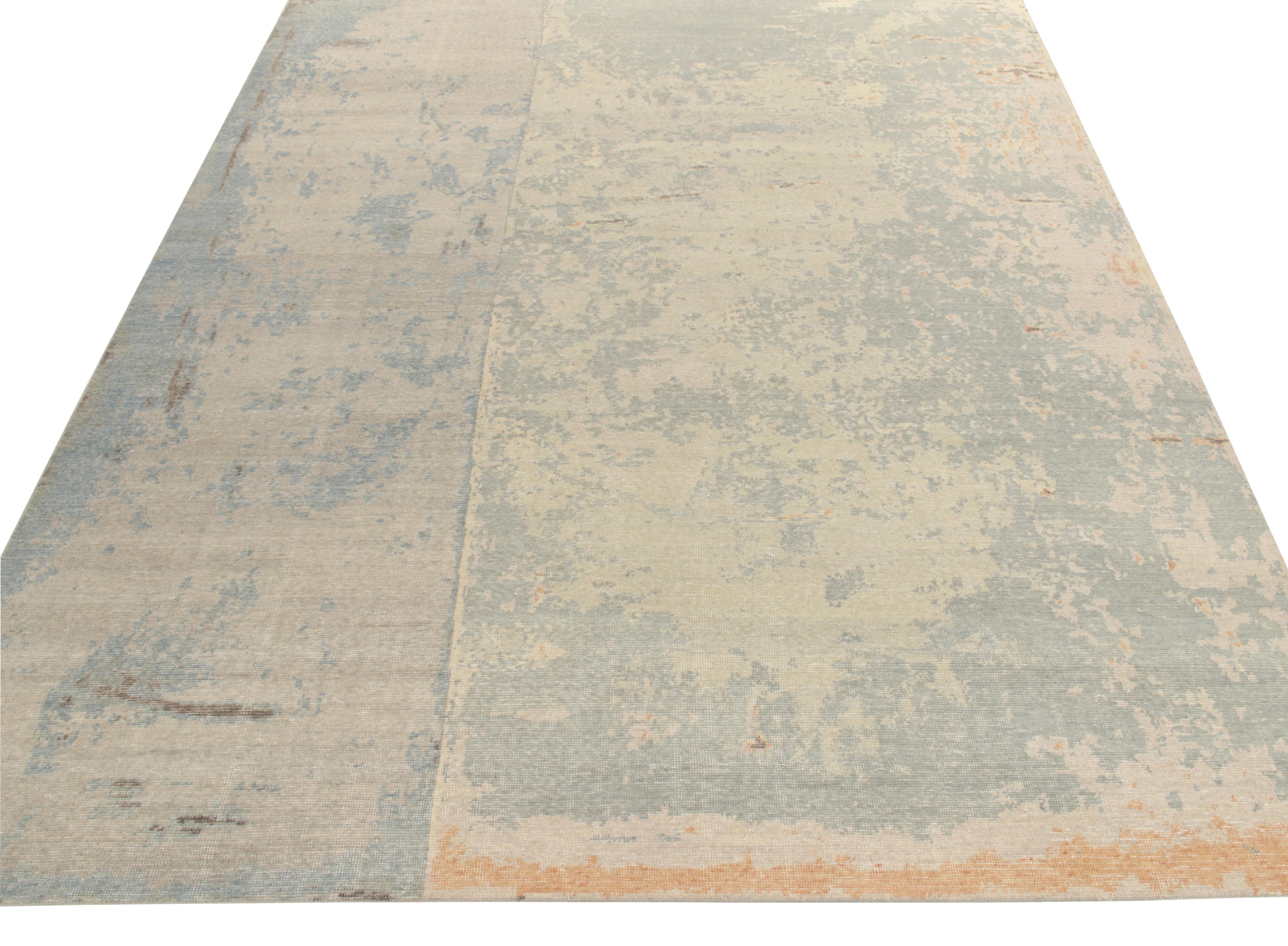 Hand-knotted in wool, a 9x12 contemporary piece from Rug & Kilim’s Homage Collection featuring an abstract pattern in an abrashed sky blue & light grey backdrop—creamy beige & industrial grey tones prevailing on the borders. Carrying an enticing