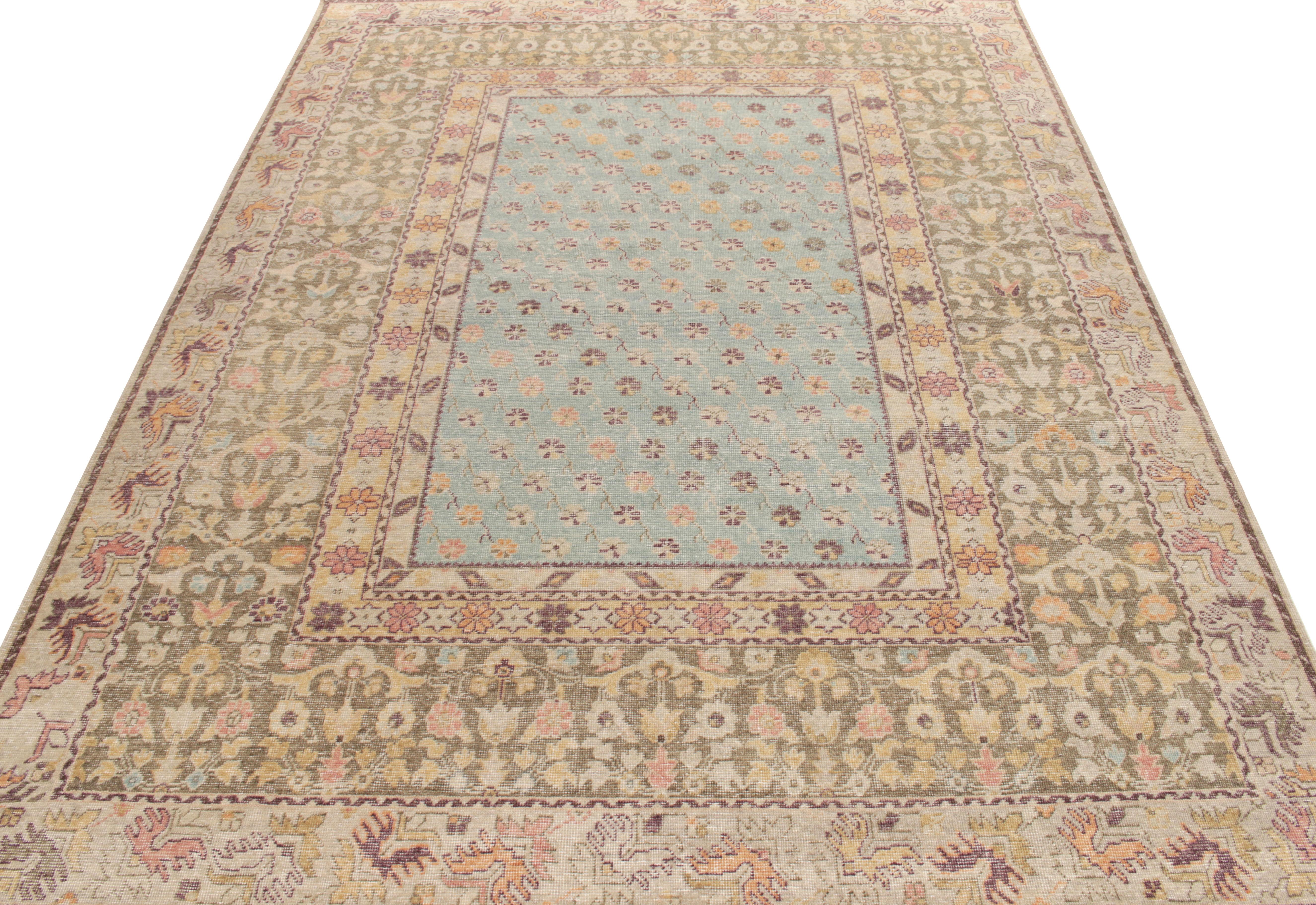 A 9x12 distressed style rug from Rug & Kilim’s Homage collection inspired by mid-century European style in muted tones of aubergine, silver gray, cream, sky blue & gold transitioning joyfully into a floral pattern relishing classic aesthetics for