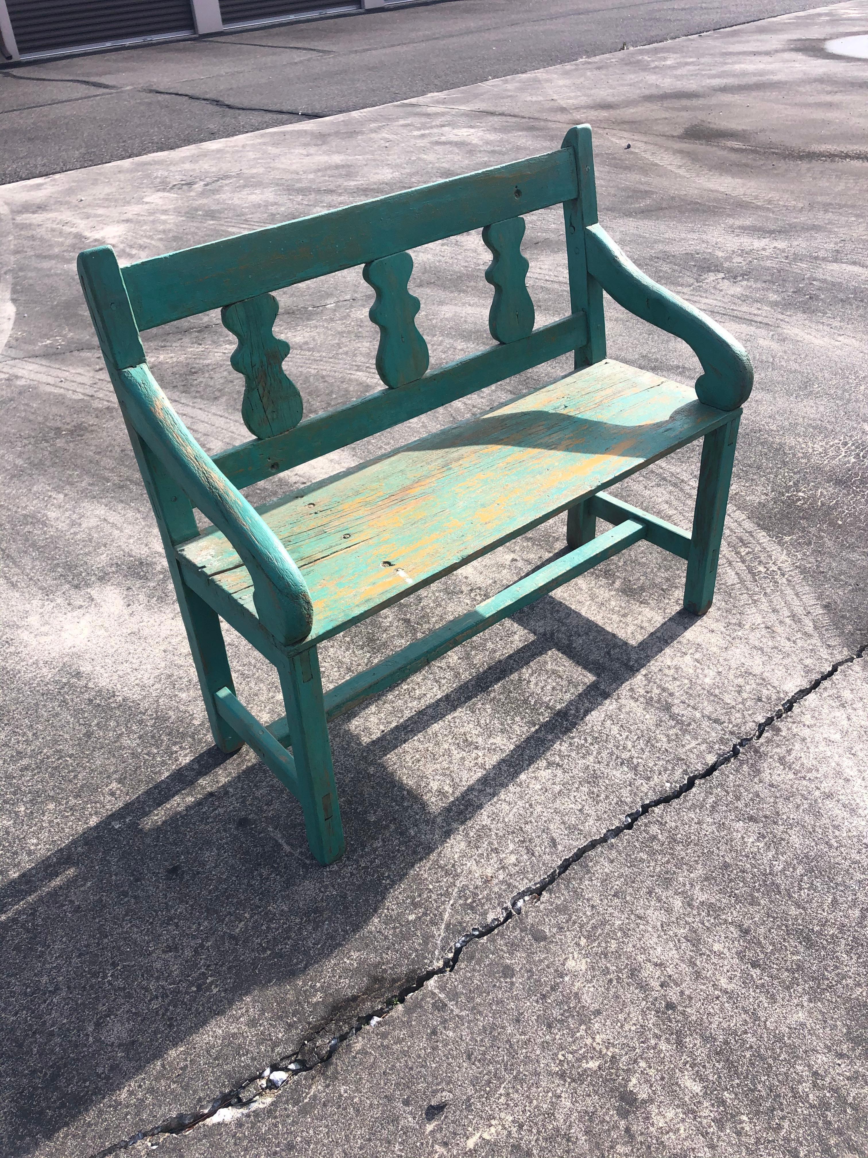 Wonderful old rustic Santa Fe bench having original weathered turquoise paint with yellow undercoat showing through.
Measures: Arm height 24.