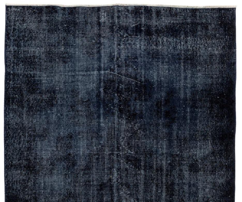 Ein minimalistischer türkischer Teppich im Vintage-Look, der in der Farbe Marineblau überfärbt ist.
Der Teppich ist fein handgeknüpft, hat einen niedrigen Wollflor auf Baumwollgrund. Er ist in sehr gutem Zustand, professionell gewaschen, robust und