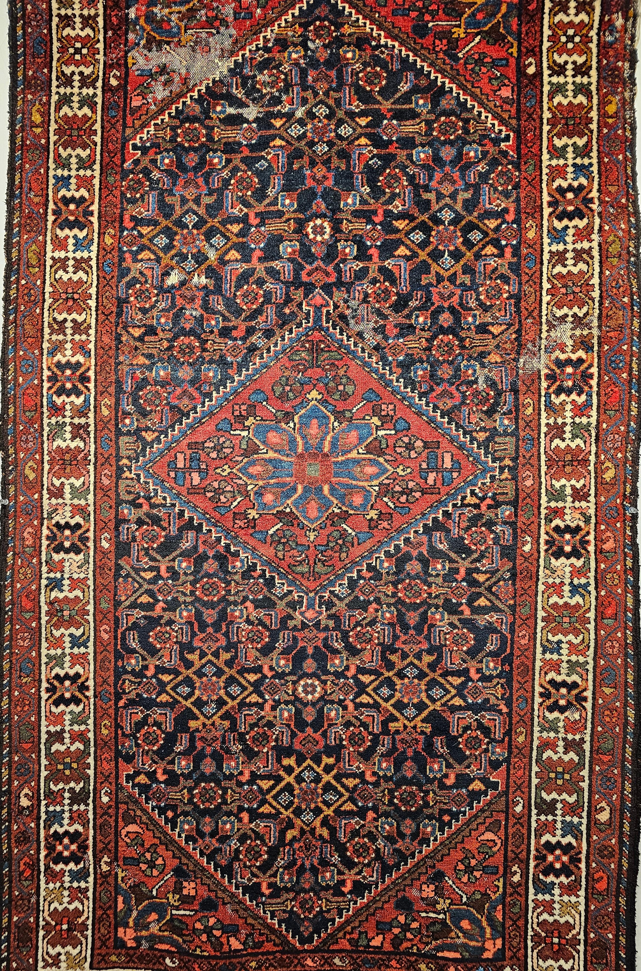 Vintage Persian Malayer area rug in an allover “Herati” design from the mid 1900s.  The Malayer rug is in a navy blue background with an ivory color border.  There is a small central medallion  in a brilliant red color background  with a geometric