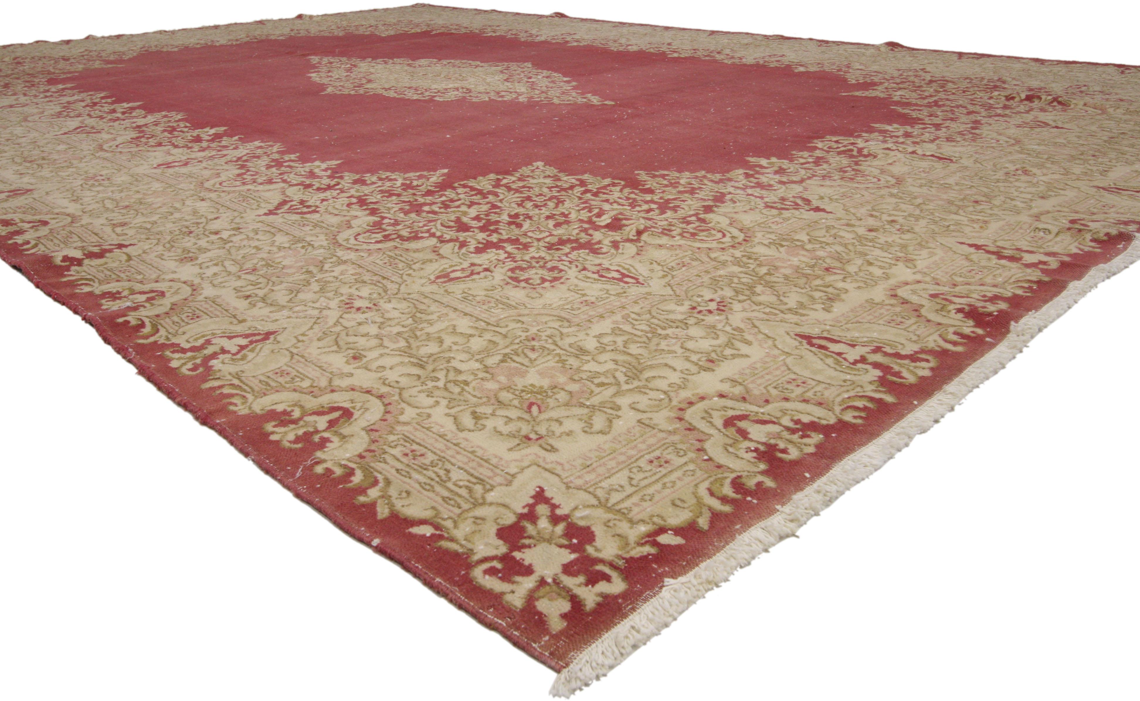 74921 distressed vintage Persian Kirman area rug with French Victorian style, Kerman rug. This French Victorian-era style Kirman palace size rug is a stunning visual display of flowers and architectural elements. An elaborate lobed Kirman medallion