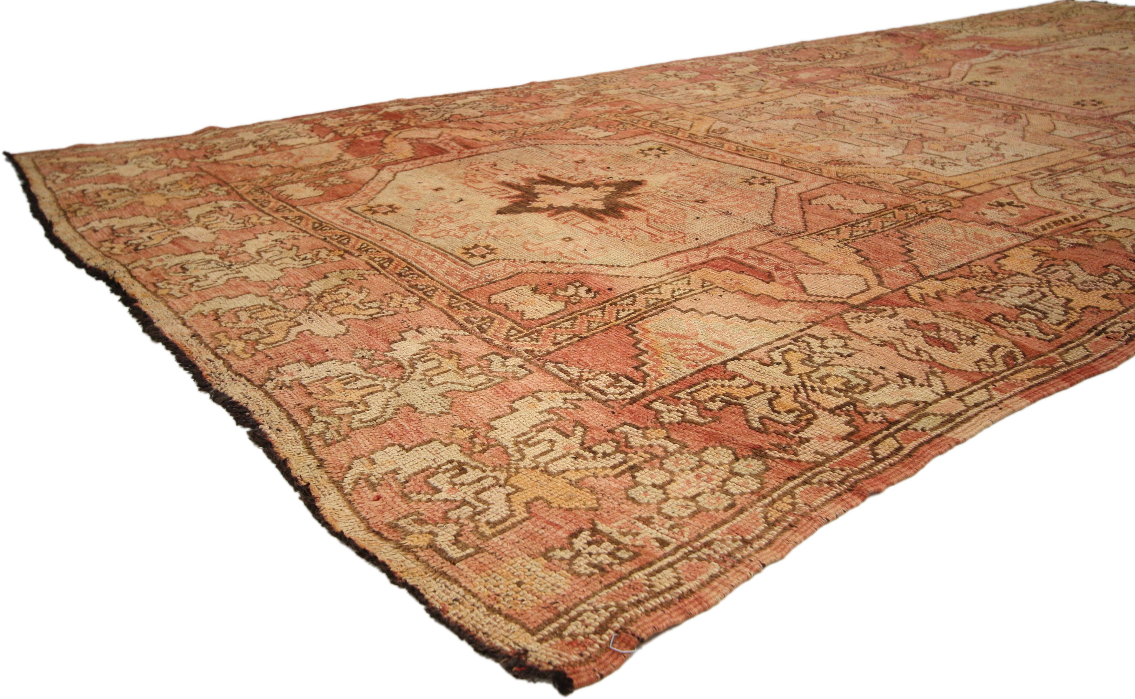 72623, distressed vintage Turkish Oushak Gallery rug with rustic Art Deco style. This hand knotted wool distressed vintage Turkish Oushak gallery rug features three gul amulets in a compartment style panel. There are different symbols in each