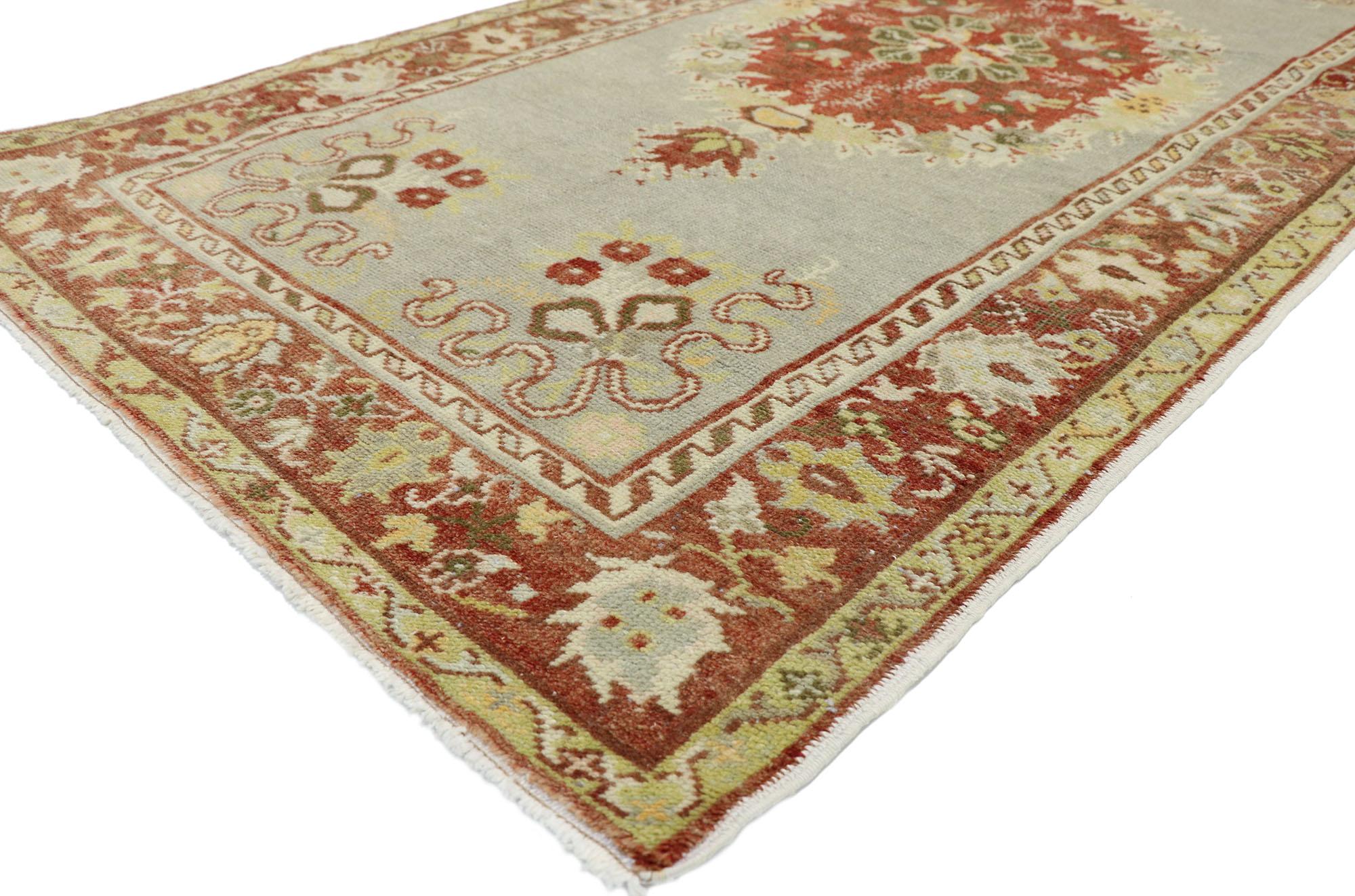 52746, tapis turc Oushak vintage en mauvais état, style géorgien rustique et romantique. Ce tapis d'accent turc Oushak, en laine nouée à la main, présente un médaillon central rond rempli de feuillage et de fleurs dans un champ ouvert gris clair.