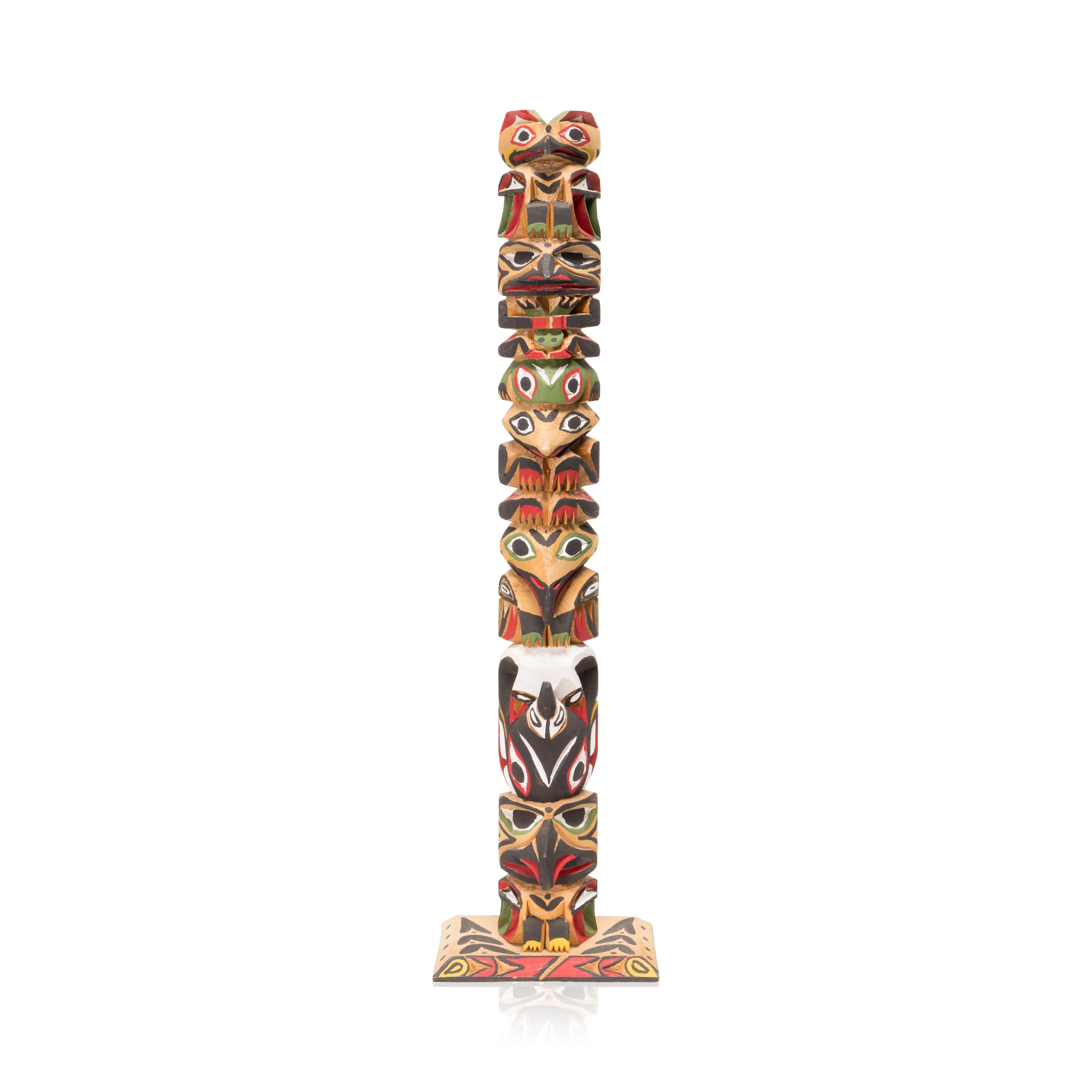 (1933-1988) This finely crafted wood totem pole is by Ditidaht/Nuu-Chah-Nulth master carver Raymond Williams, the father of the current generation of William's carvers. The carved totem pole features and eagle, frog, and an orca. Signed on back.
