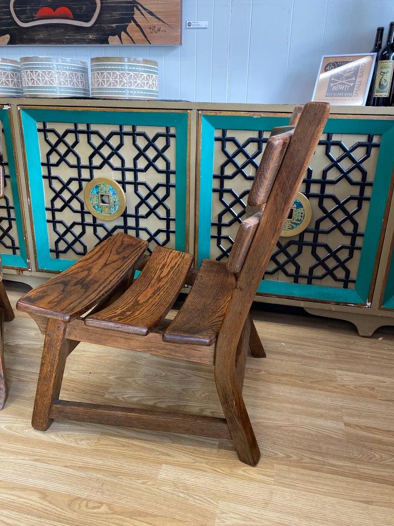 Four sold in pairs, Dittmann & Co for AWA Holland brutalist fireplace lounge chairs circa 1960s, Netherlands. Four dark stained solid oak armless lounge chairs feature a rounded slatted back and seats. They are sold as four, please inquire about