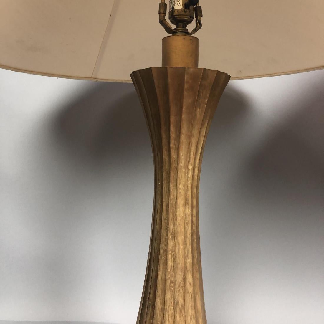 A pair of corseted fluted table lamps designed by Robert Kuo for McGuire 
Burnished gilt finish, possibly on brass. 
The fluted form with a matching finial 
Top of lamp has the initial 