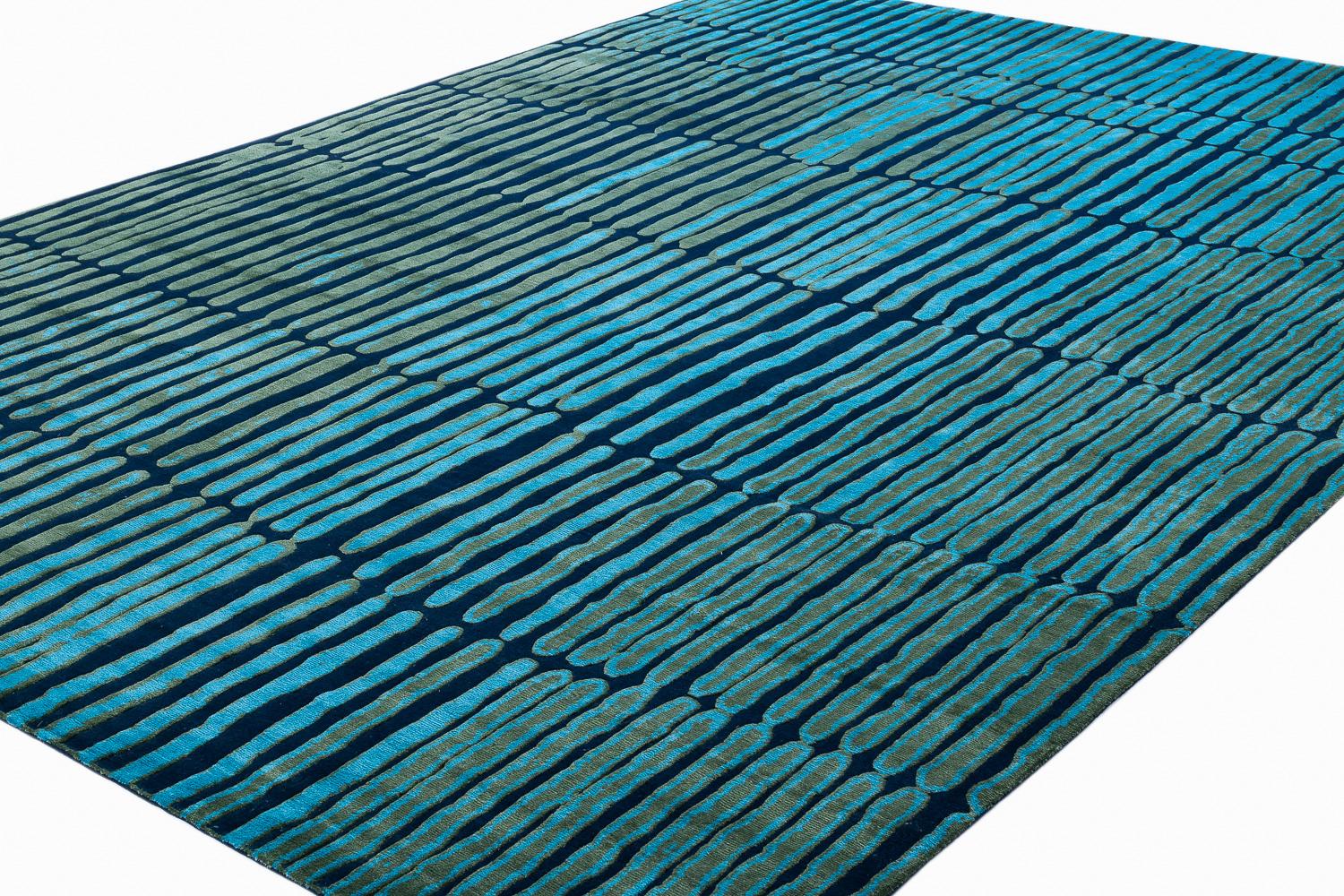 A newer abstract design by Joseph Carini, Divali is a 100 knot carpet, hand knotted with silk and wool. This luxurious area rug has a subtle texture- the wool background is slightly lower than the silk design. The blue and green colors are vibrant