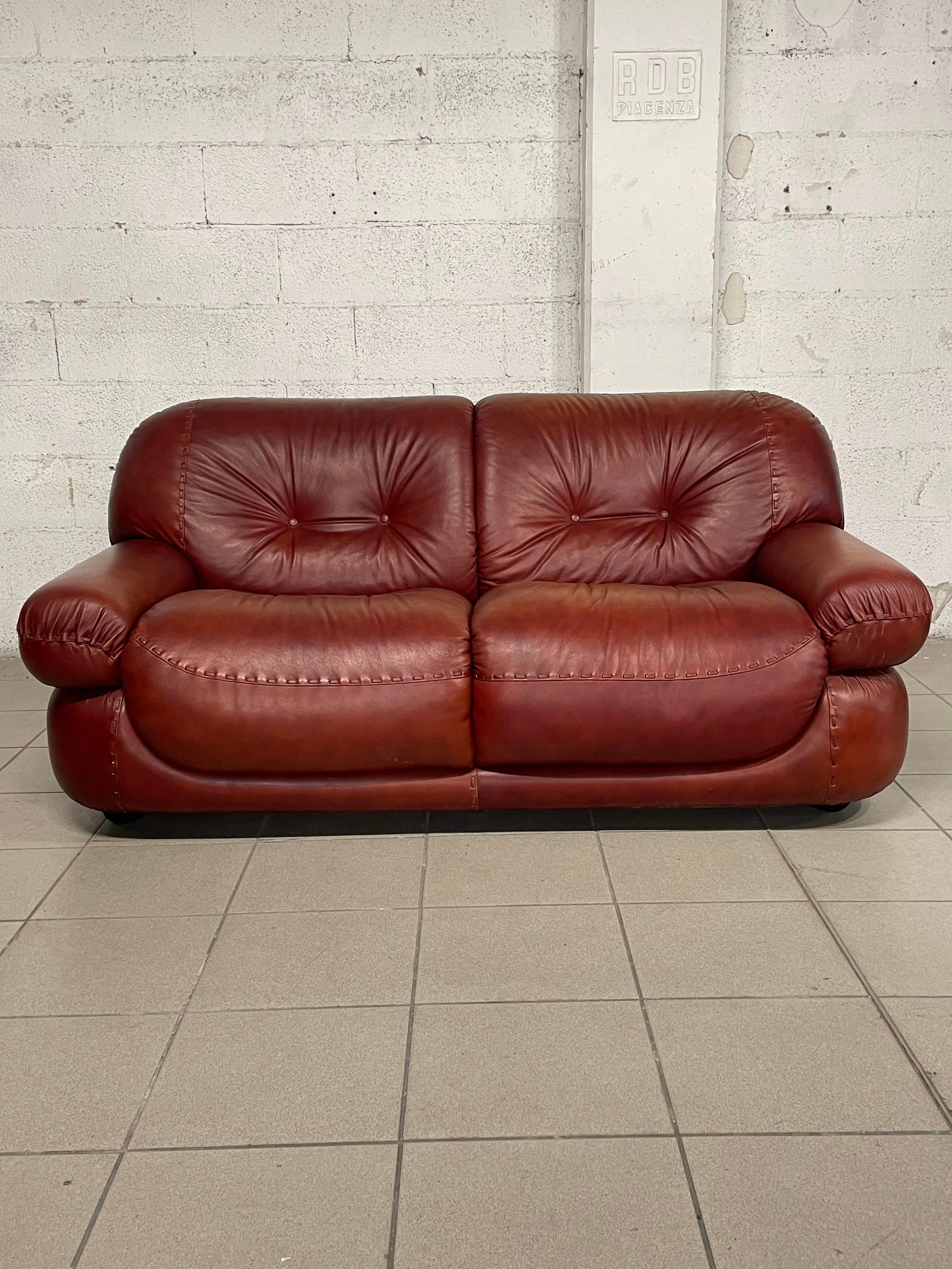 Two-seater burgundy/antique leather sofa Sapporo model produced by MOBILGIRGI (Italy) in 1970s.

Comfortable in the seat as it appears in the photo.
Soft, elegant and cozy, thanks to its rounded shapes.
The leather patina gives this sofa an extra