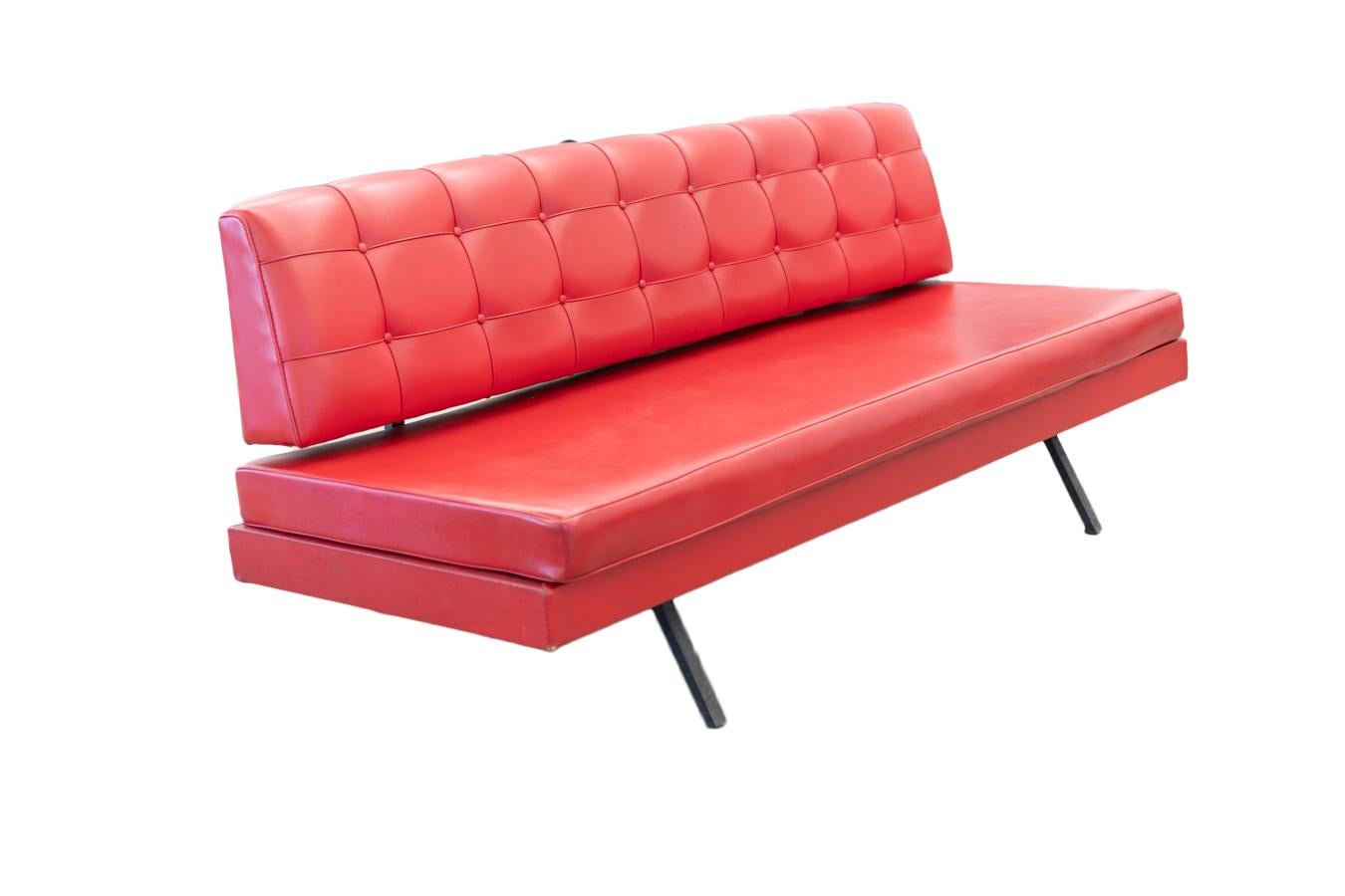 Red faux leather 1970s sofa with black iron frame and buttoned backrest
