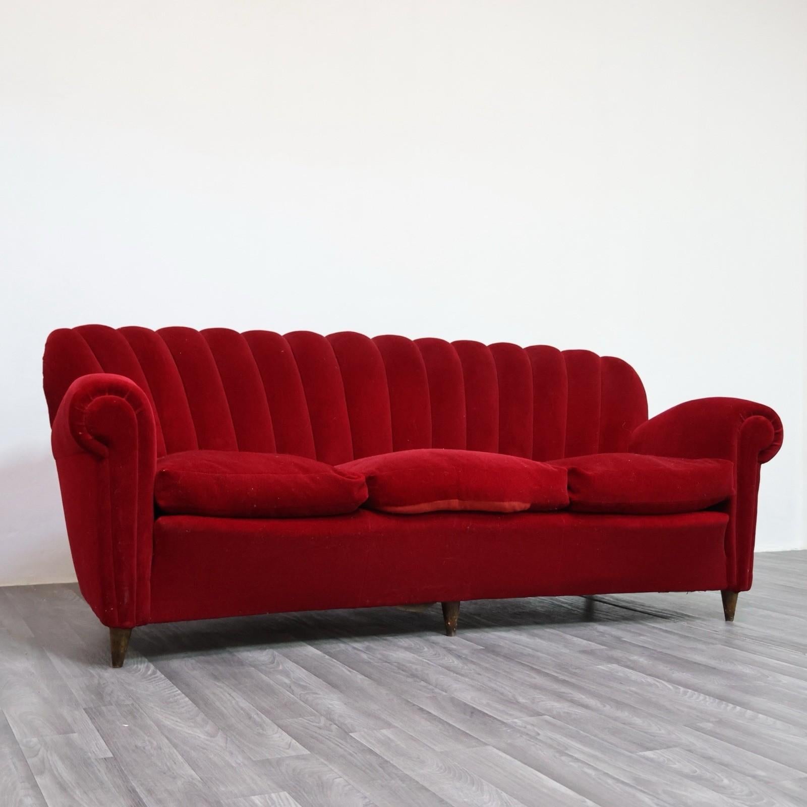 Élégant divan Art déco attribué à Guglielmo Ulrich, réalisé dans les années '40 et rivestito dans son propre tessuto di velluto original color rosso intenso. La structure présente les caractéristiques des lignes sinueuses typiques du designer, avec