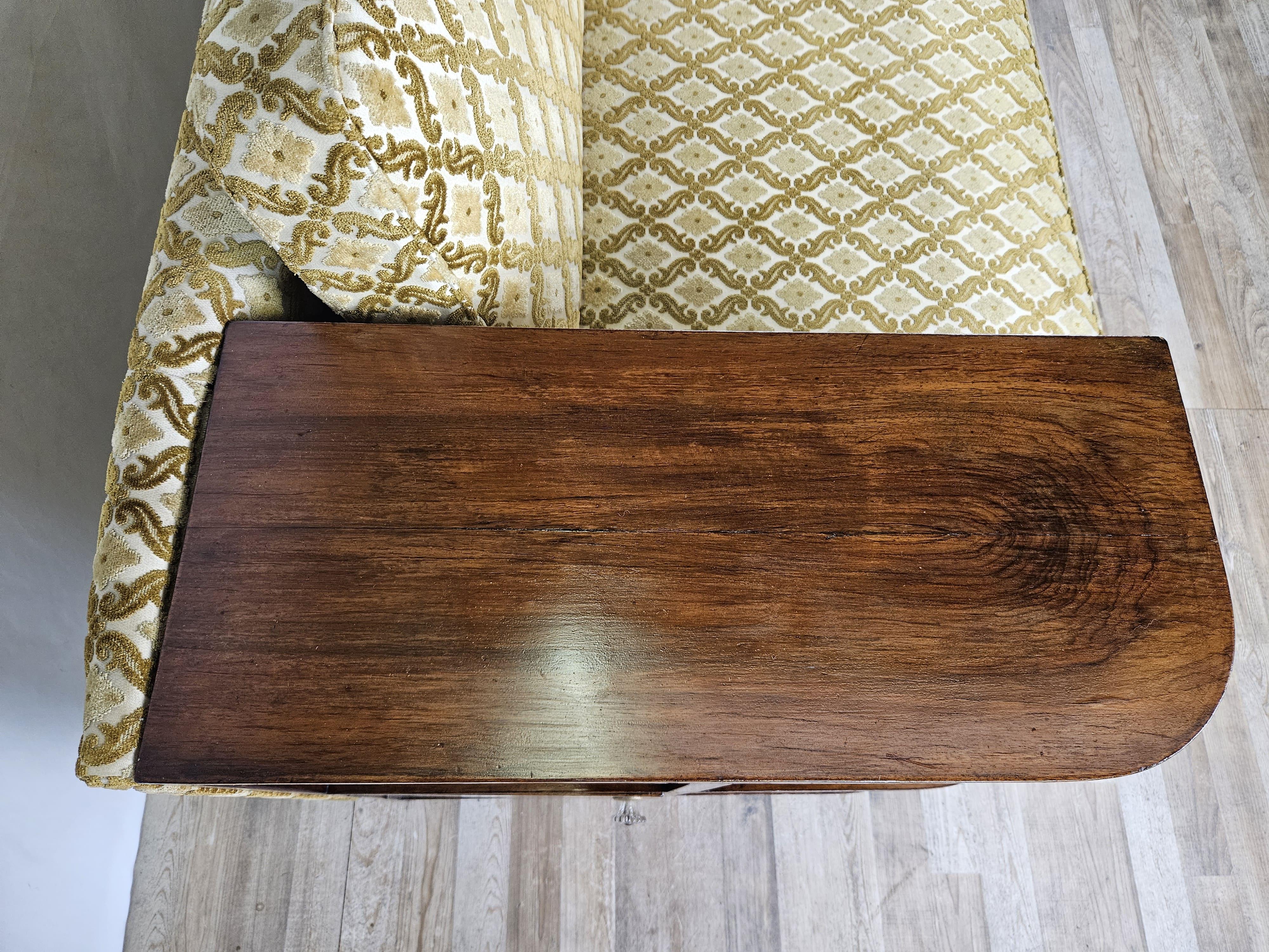 Elegant walnut-root sofa from the early 1930s Art Deco period, seat and back have cushions upholstered and reupholstered circa 1990.

Very distinctive, decorated with brass studs around the perimeter and modern and functional design.

On the right