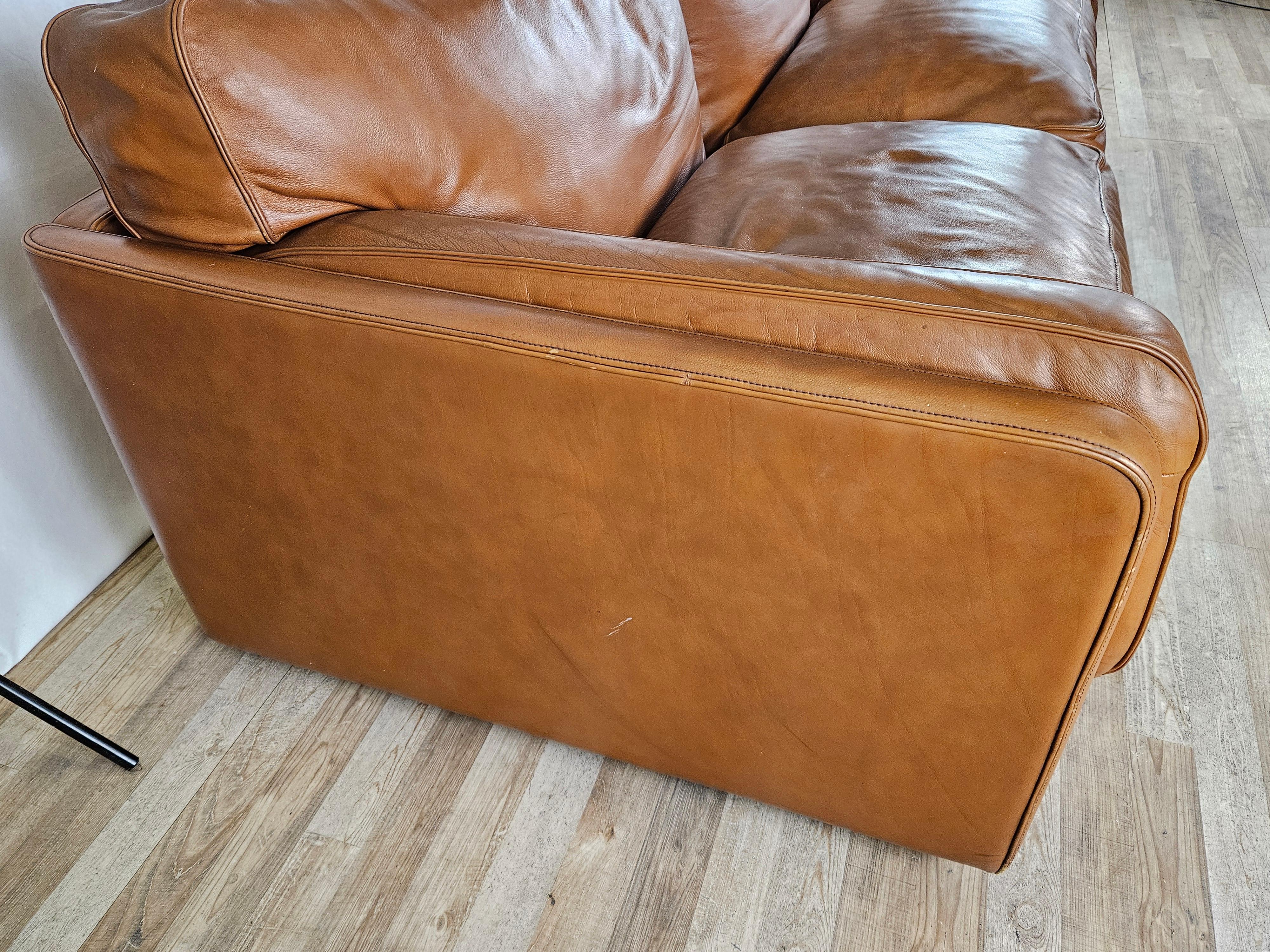 Iconic Italian-made sofa from the 1970s, made by Poltrona Frau for a high-end design that will enhance any room where placed.

This is a three-seater sofa in cognac leather with large, cozy cushions on the seat and back.

Under each seat is the
